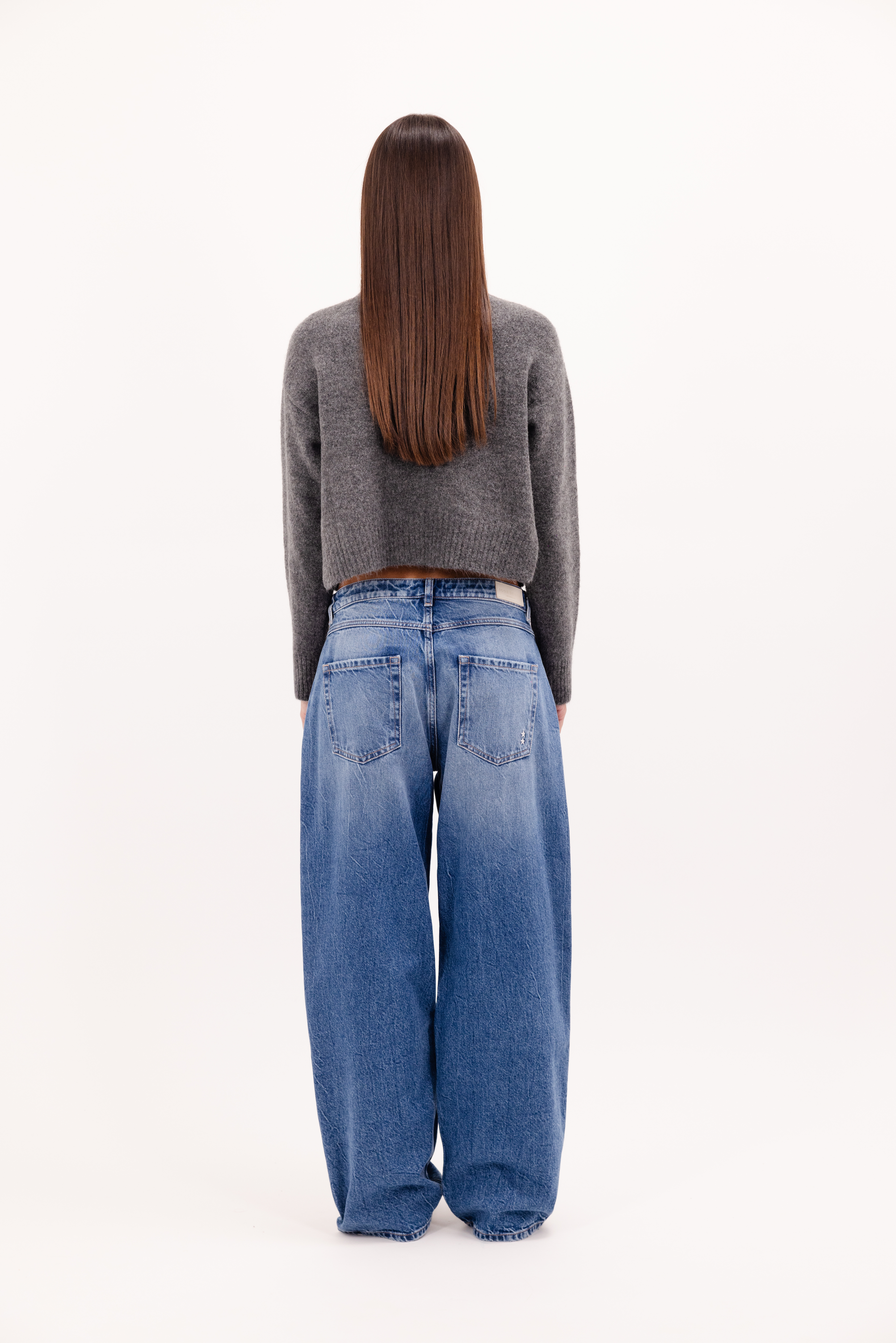 Back view of Bea women’s wide leg jeans in eclipse wash, 100% rigid cotton denim, worn by a model with a wool knit.