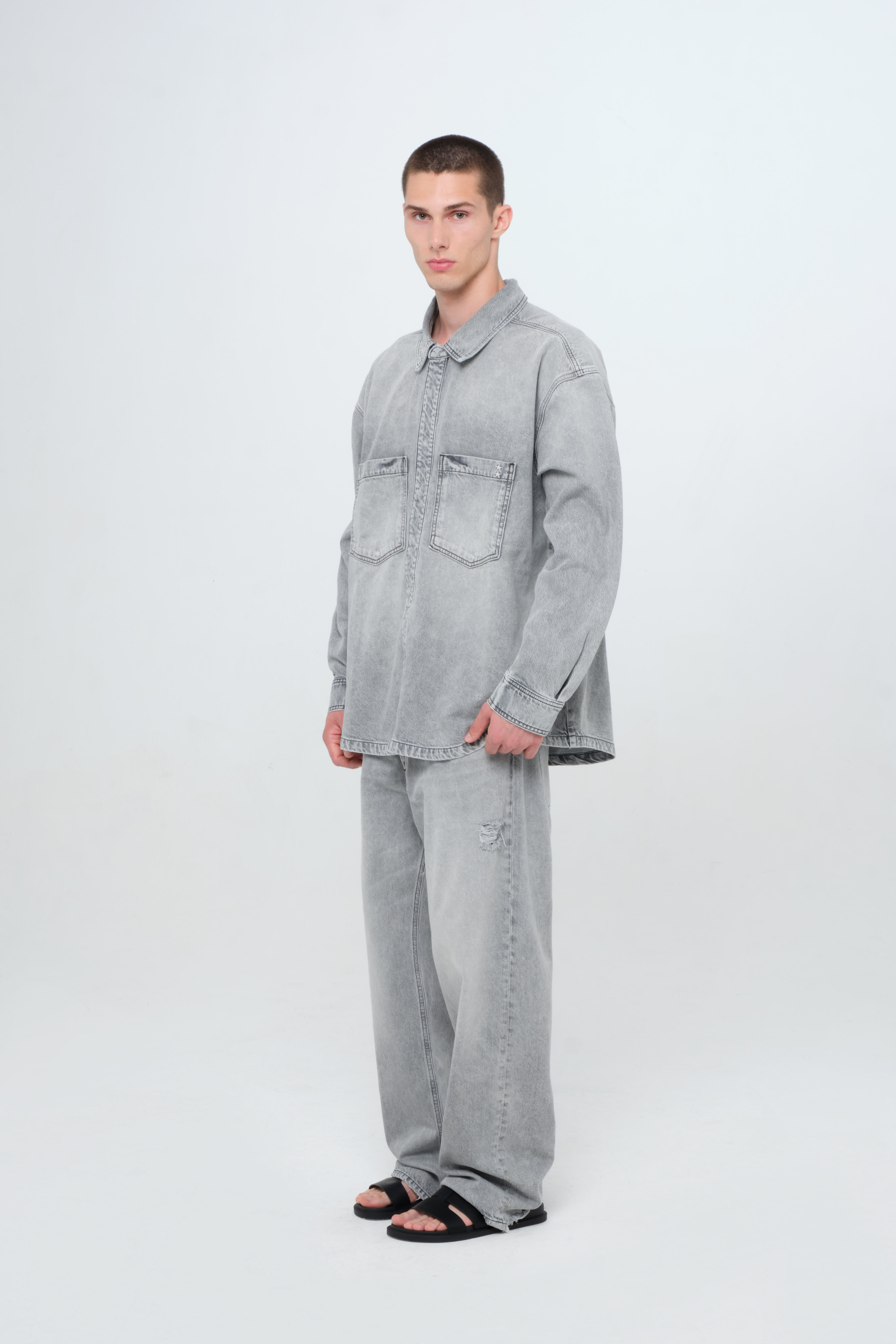 Billy men’s oversize shirt in gray wash, 100% rigid cotton denim, worn by a model with jeans.