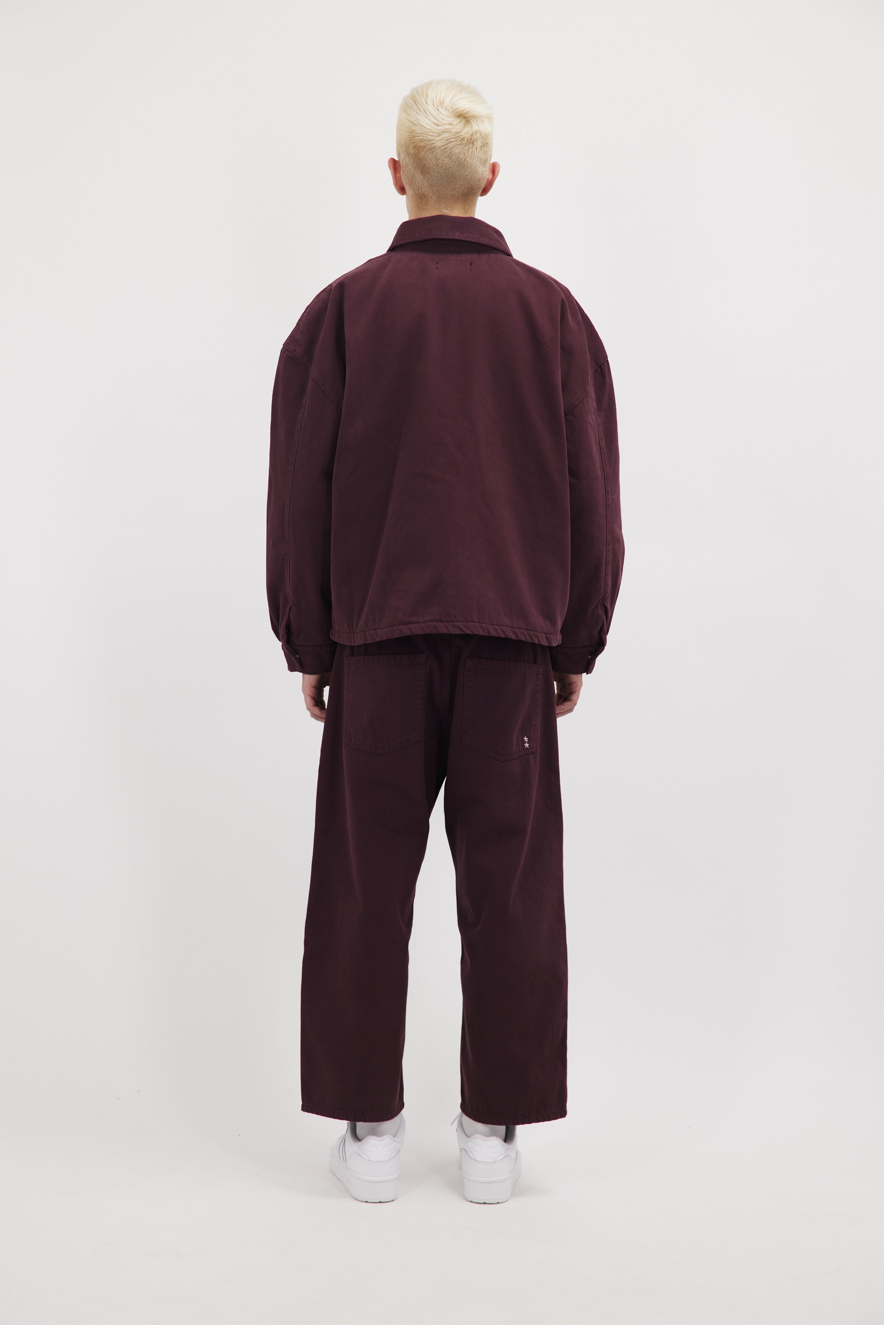 Back view of Chandler men’s jacket in cherry wash, 100% rigid cotton denim, worn by a model with jeans.