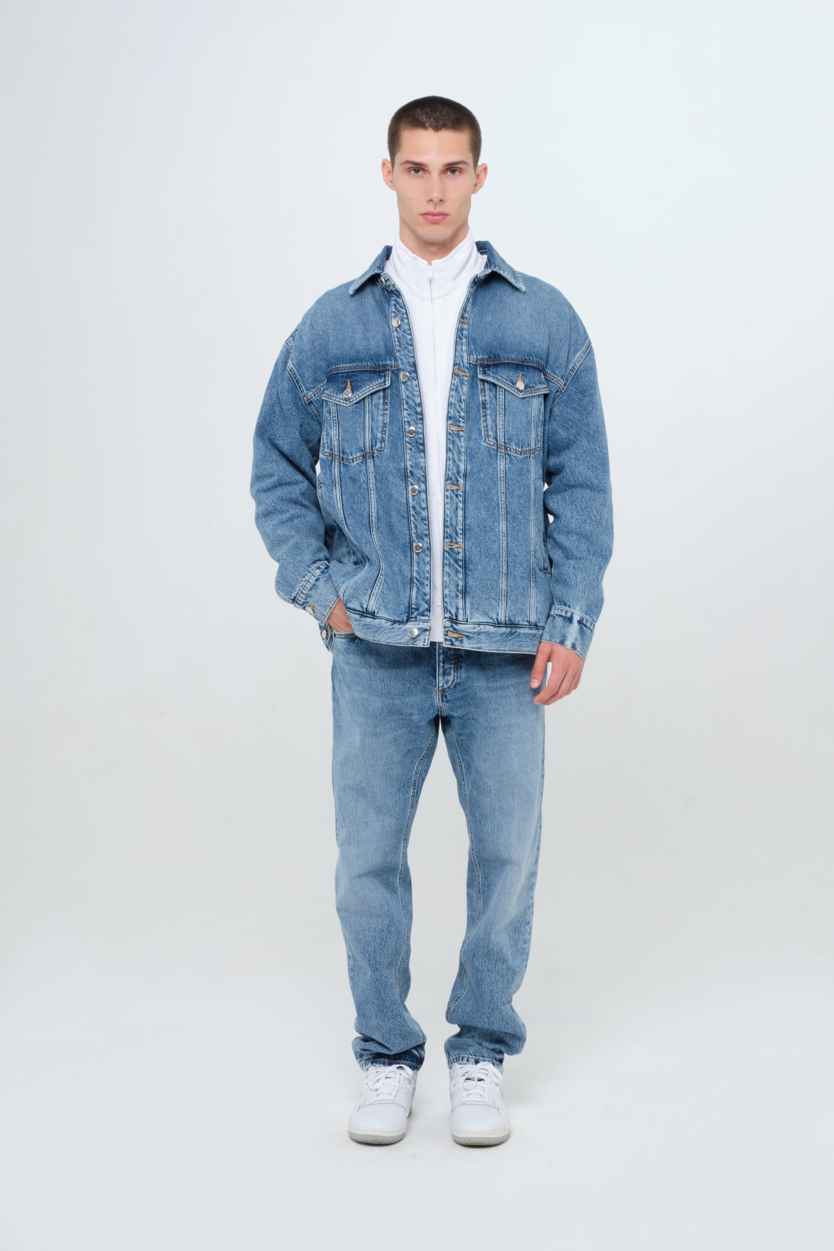 Drew men’s oversize jacket in medium wash, 100% rigid cotton denim, worn by a model with jeans.