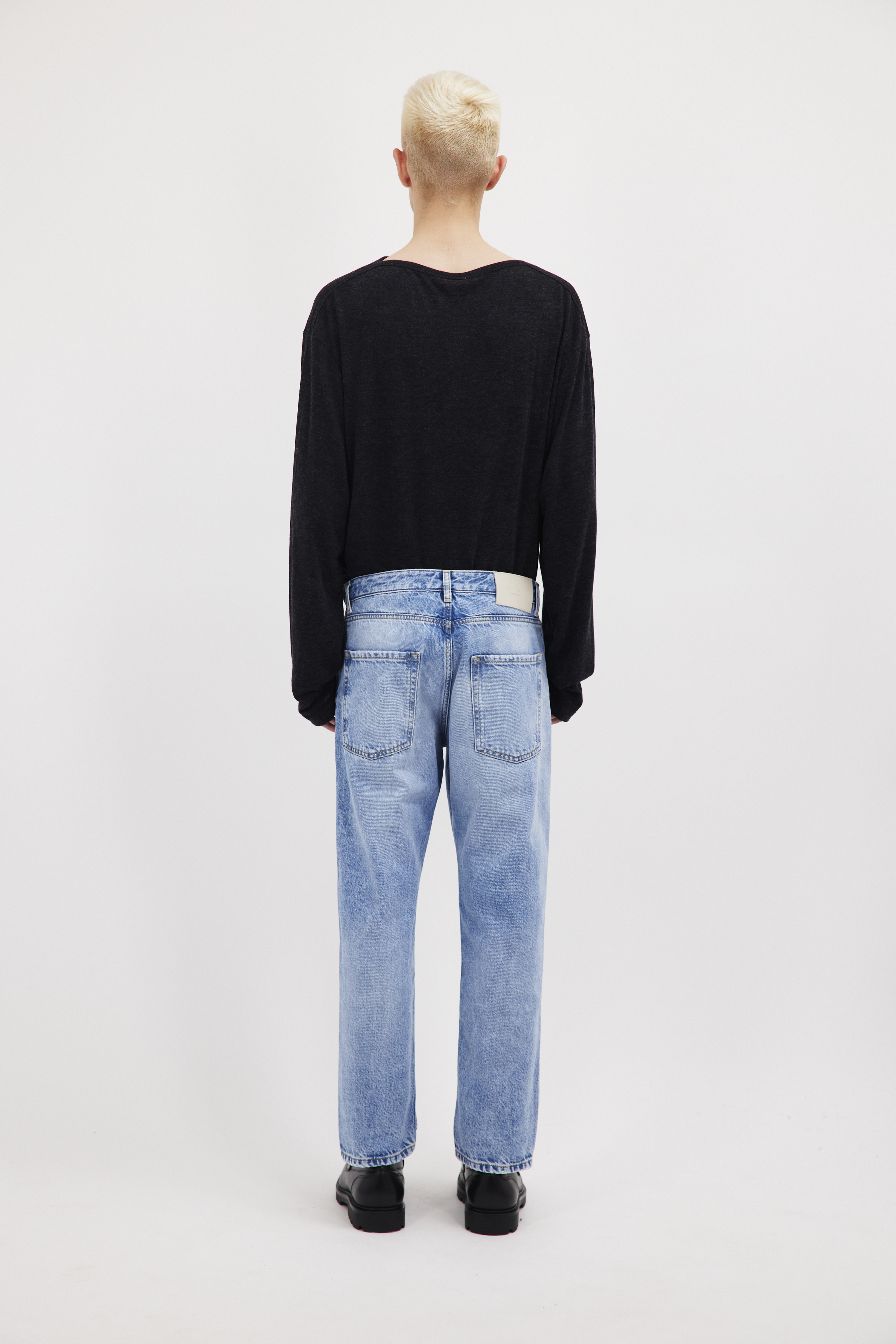 Back view of Josh men’s carrot jeans in misty blue wash, 100% rigid cotton denim, worn by a model with a black long sleeve.