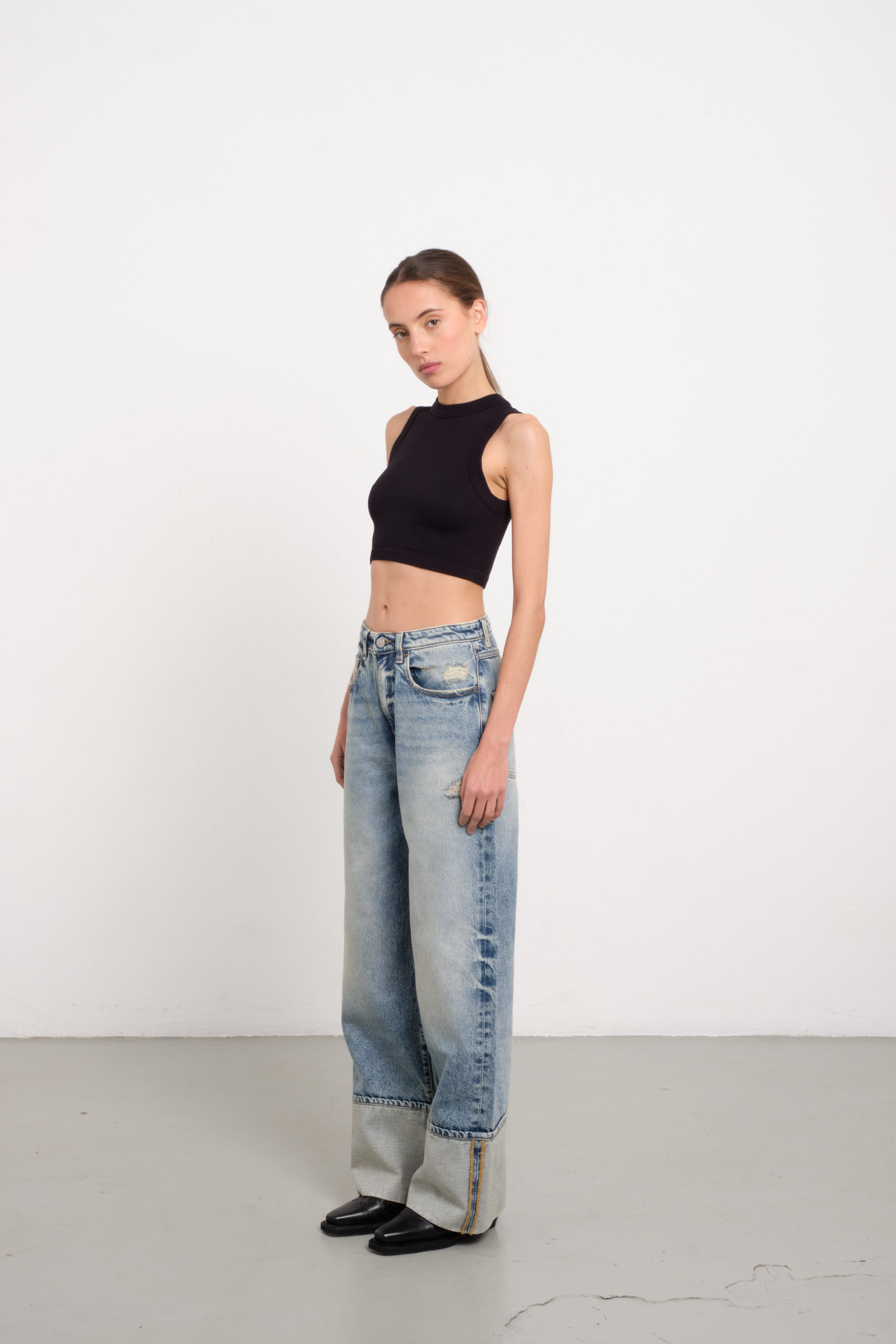 Kiki women’s wide leg jeans in old effect wash, 100% rigid cotton denim, worn by a model with a black top.