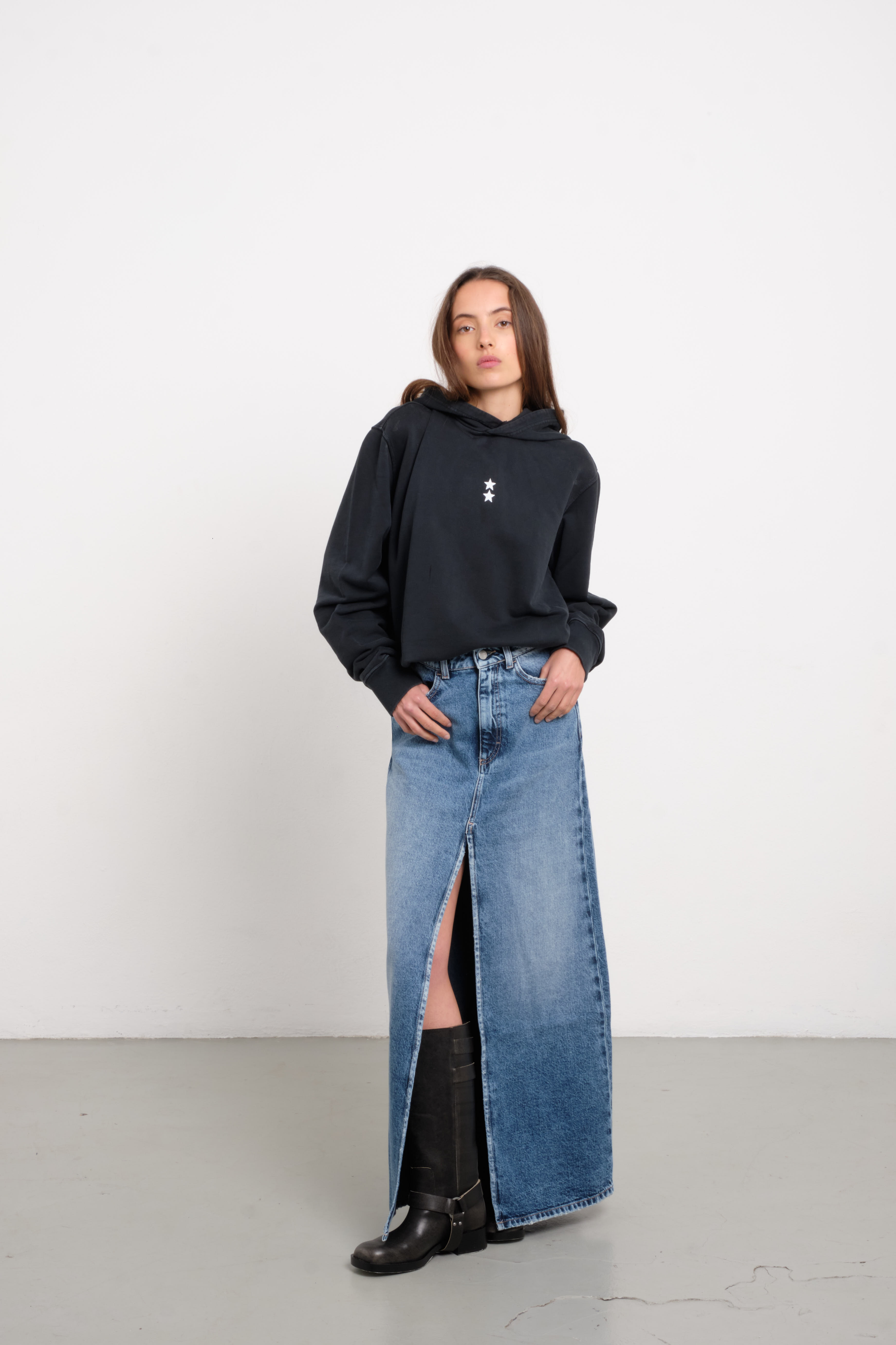 Lara women’s long skirt in medium wash, 100% rigid cotton denim, worn by a model with a black hoodie.