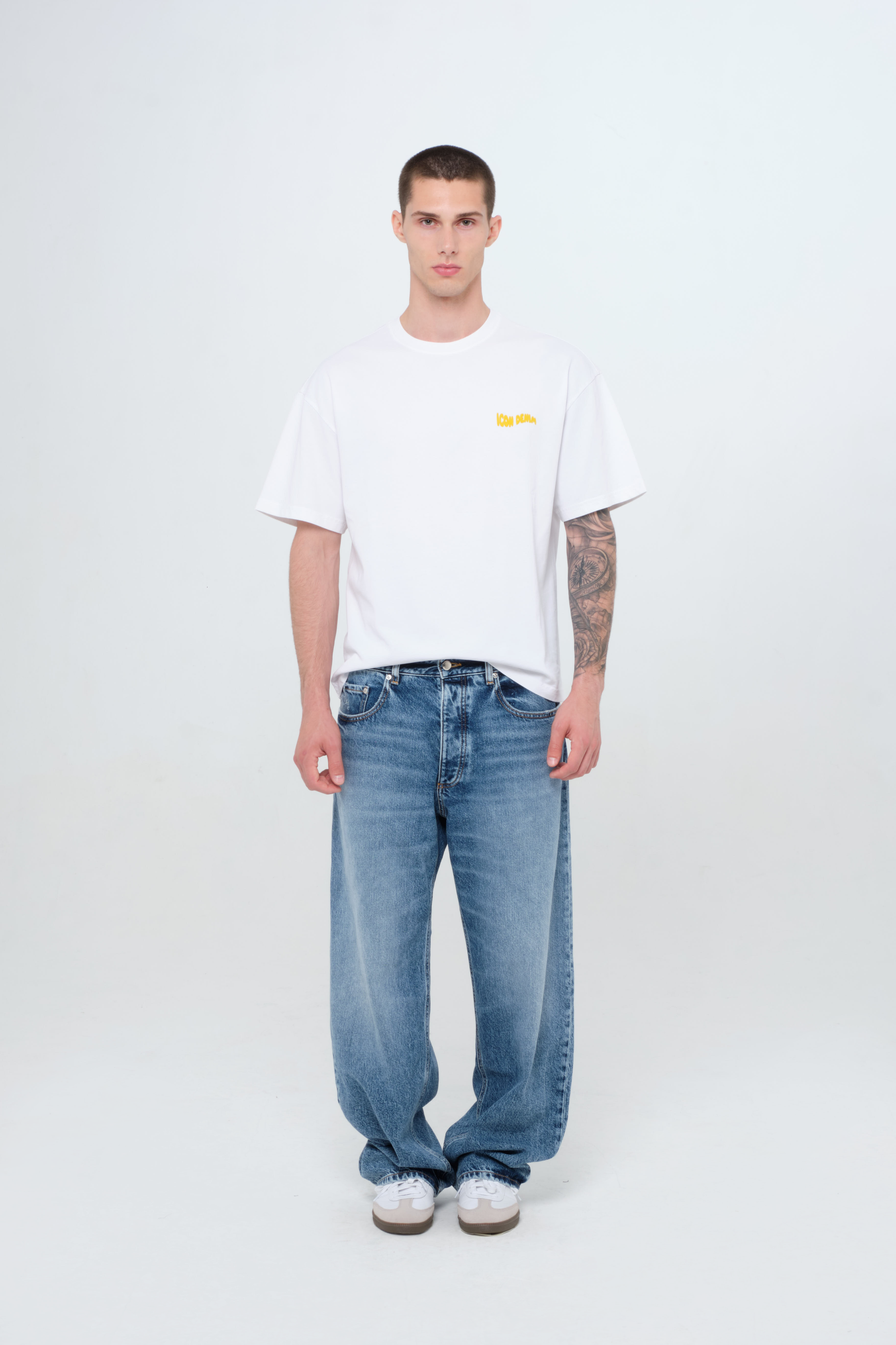 Will men’s wide leg jeans in medium wash, 100% rigid cotton denim, worn by a model with a white t-shirt.