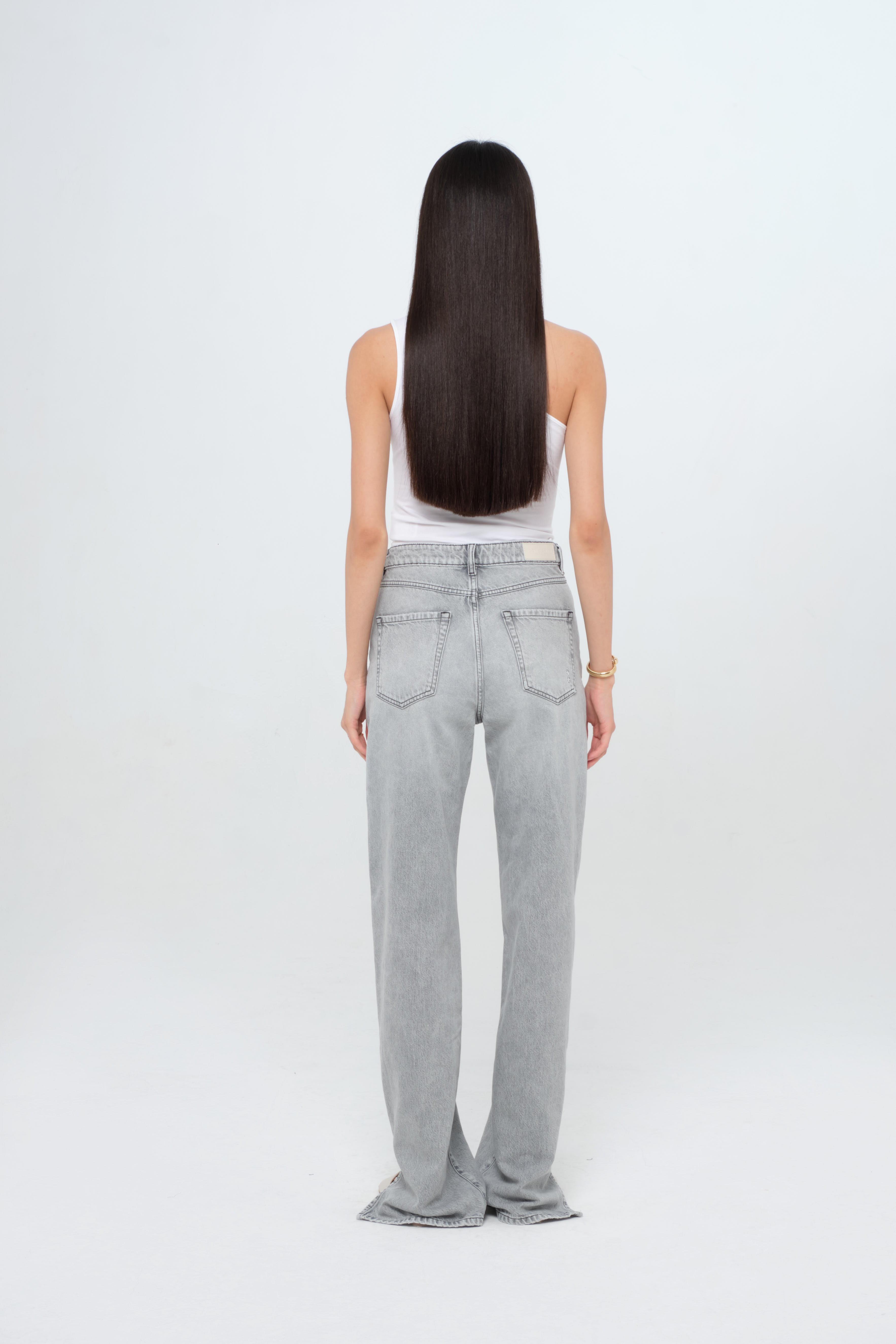 Back view of Jodie women’s straight leg jeans in gray wash, 100% rigid cotton denim, worn by a model with a white top.
