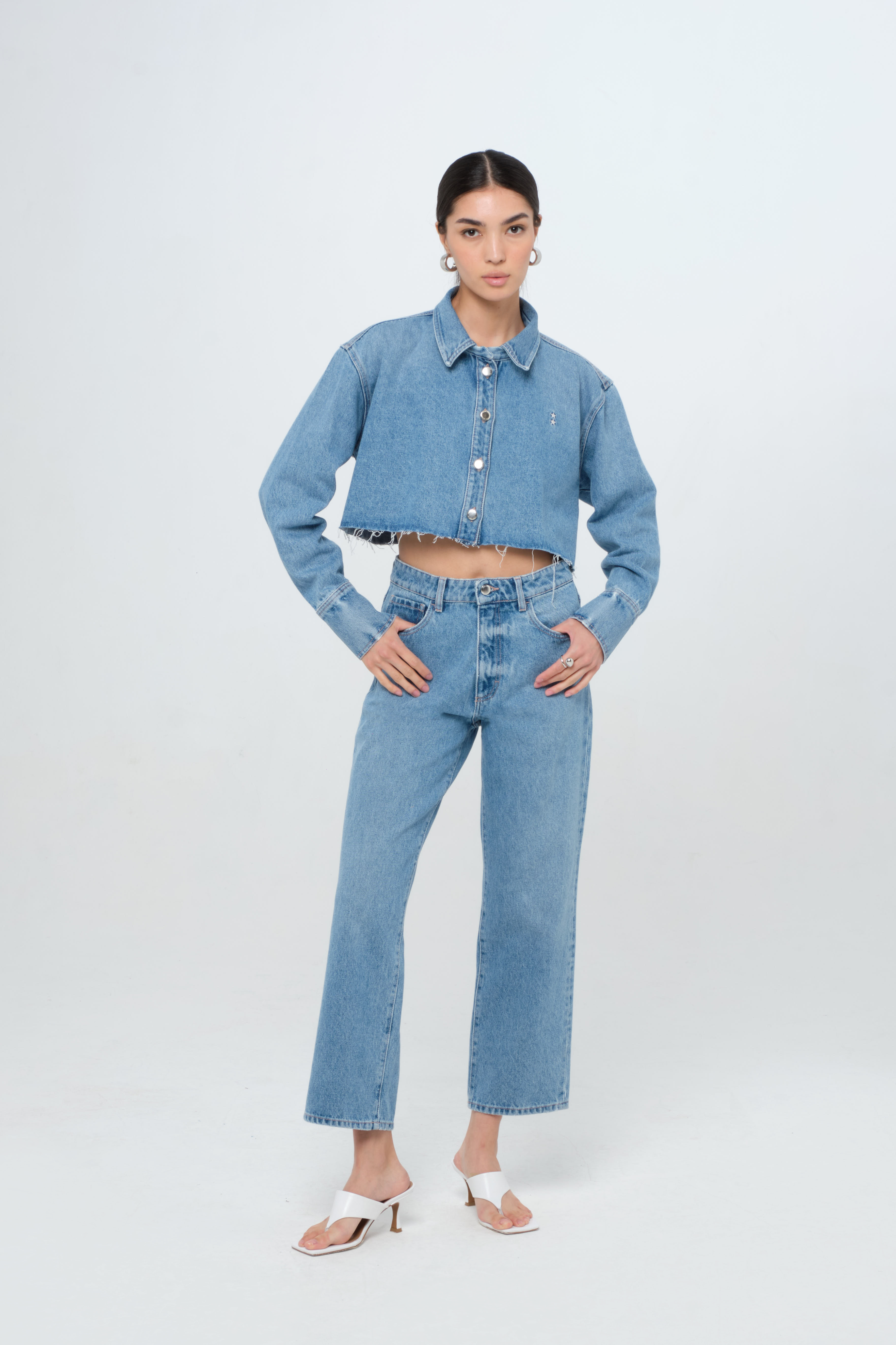 Amber Eco women’s denim crop shirt in medium wash, 100% rigid organic cotton denim, worn by a model with jeans.
