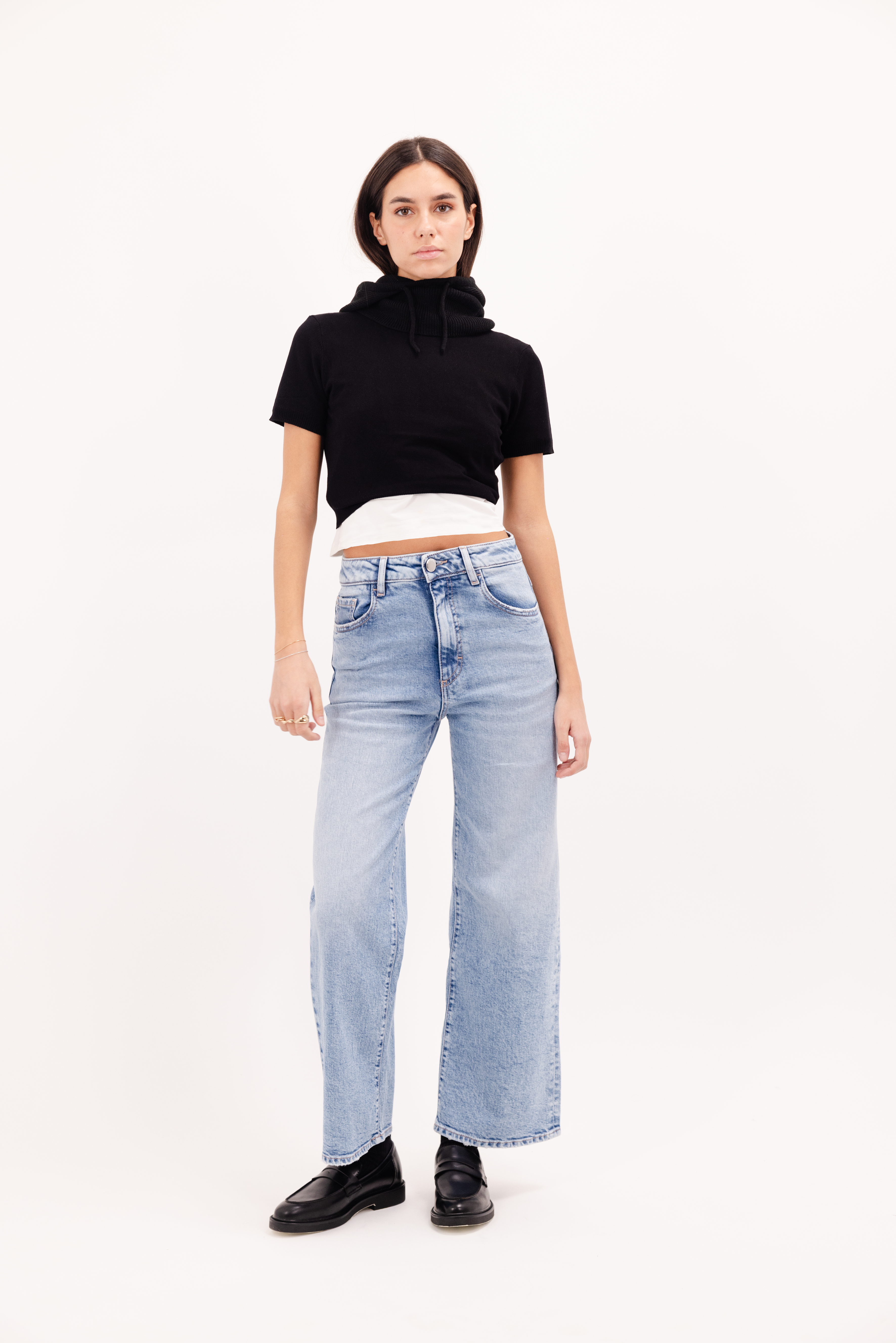 Angie women’s flared crop jeans in sky blue wash, 99% cotton denim and 1% Elastan fibers, worn by a model with a black top