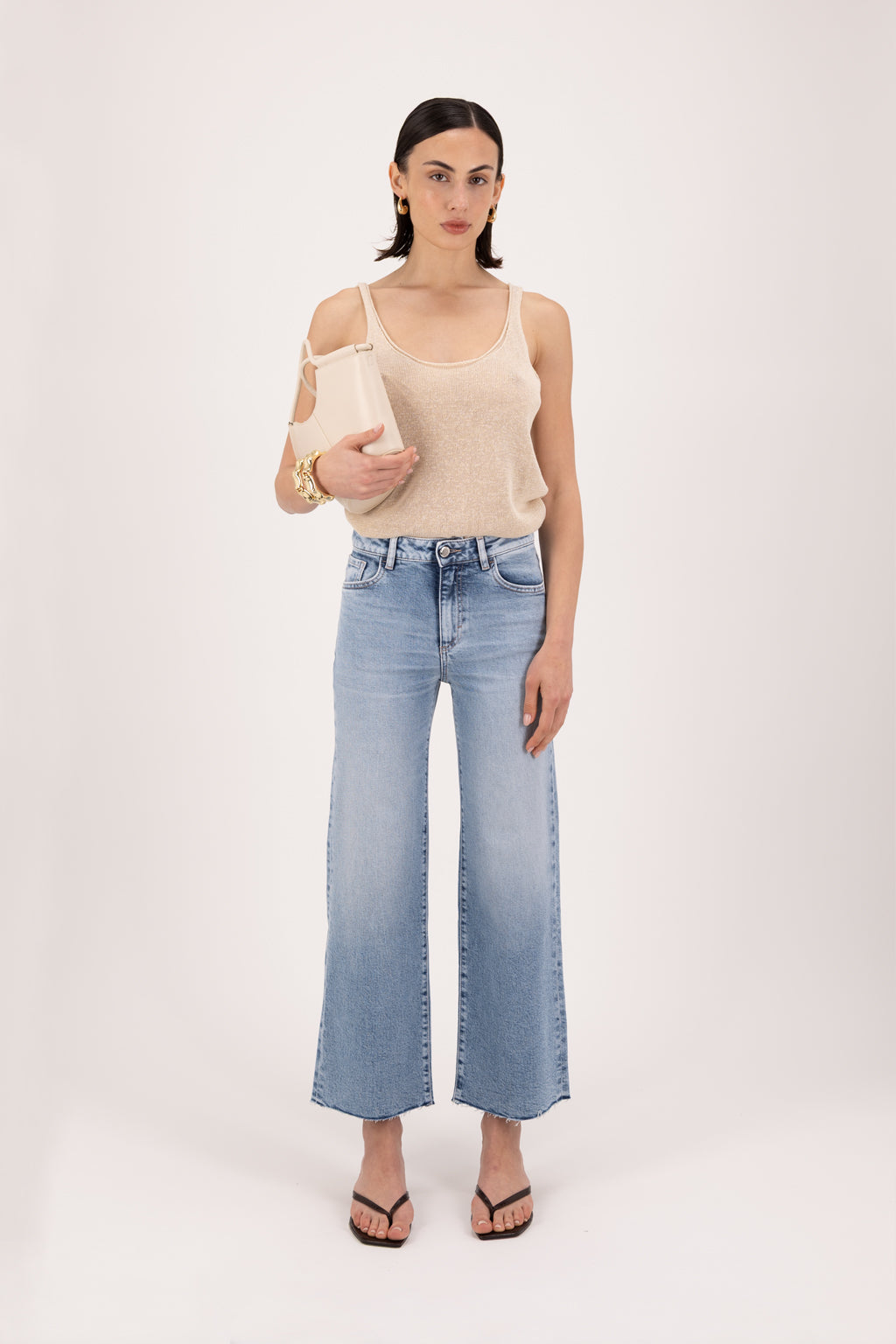 Angie women’s flared crop jeans in river wash, 99% cotton denim and 1% Elastan fibers, worn by a model with a desert tank top.