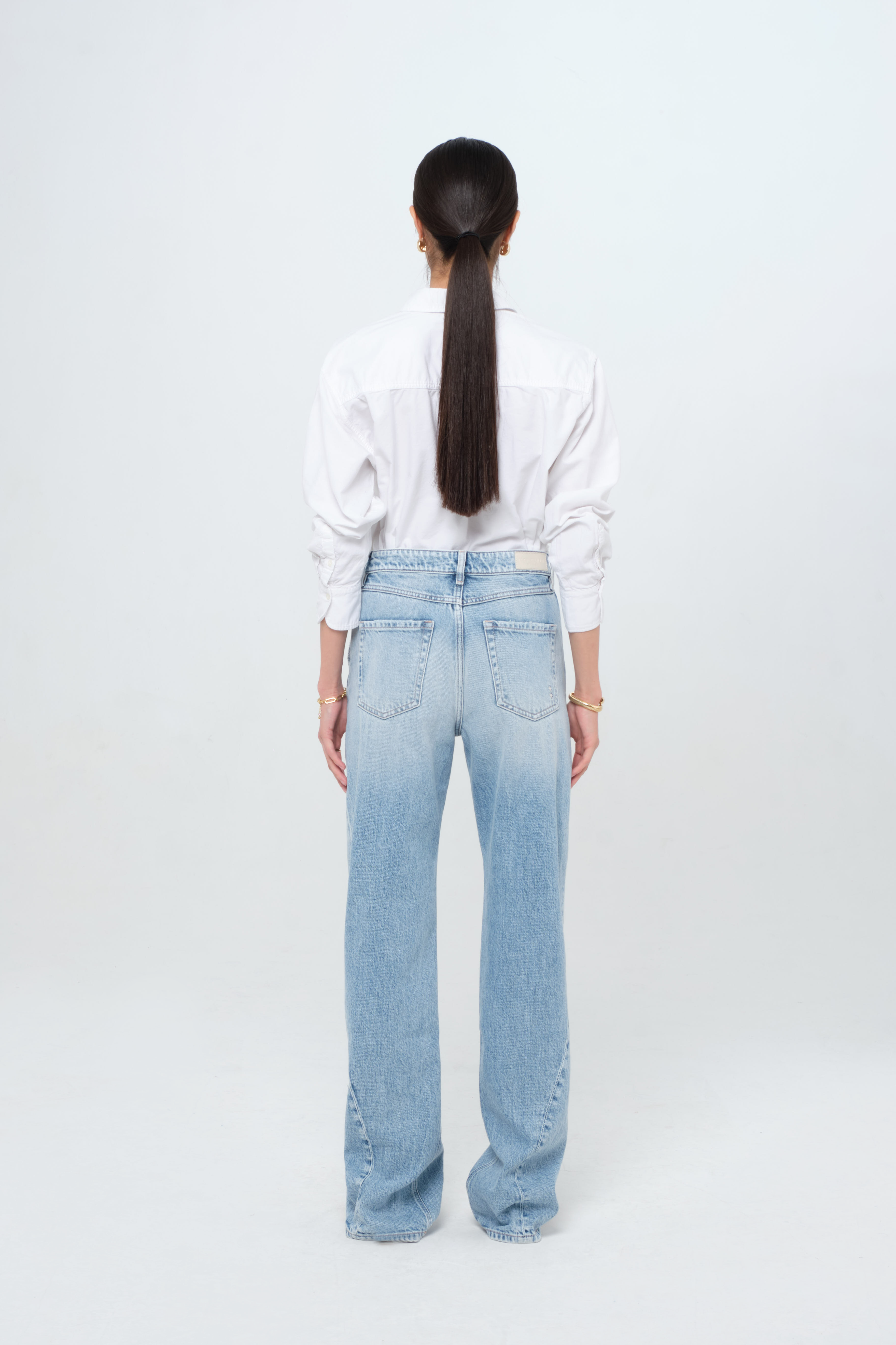 Back view of Annie women’s straight leg jeans in light wash, 100% rigid cotton denim, worn by a model with a white shirt.