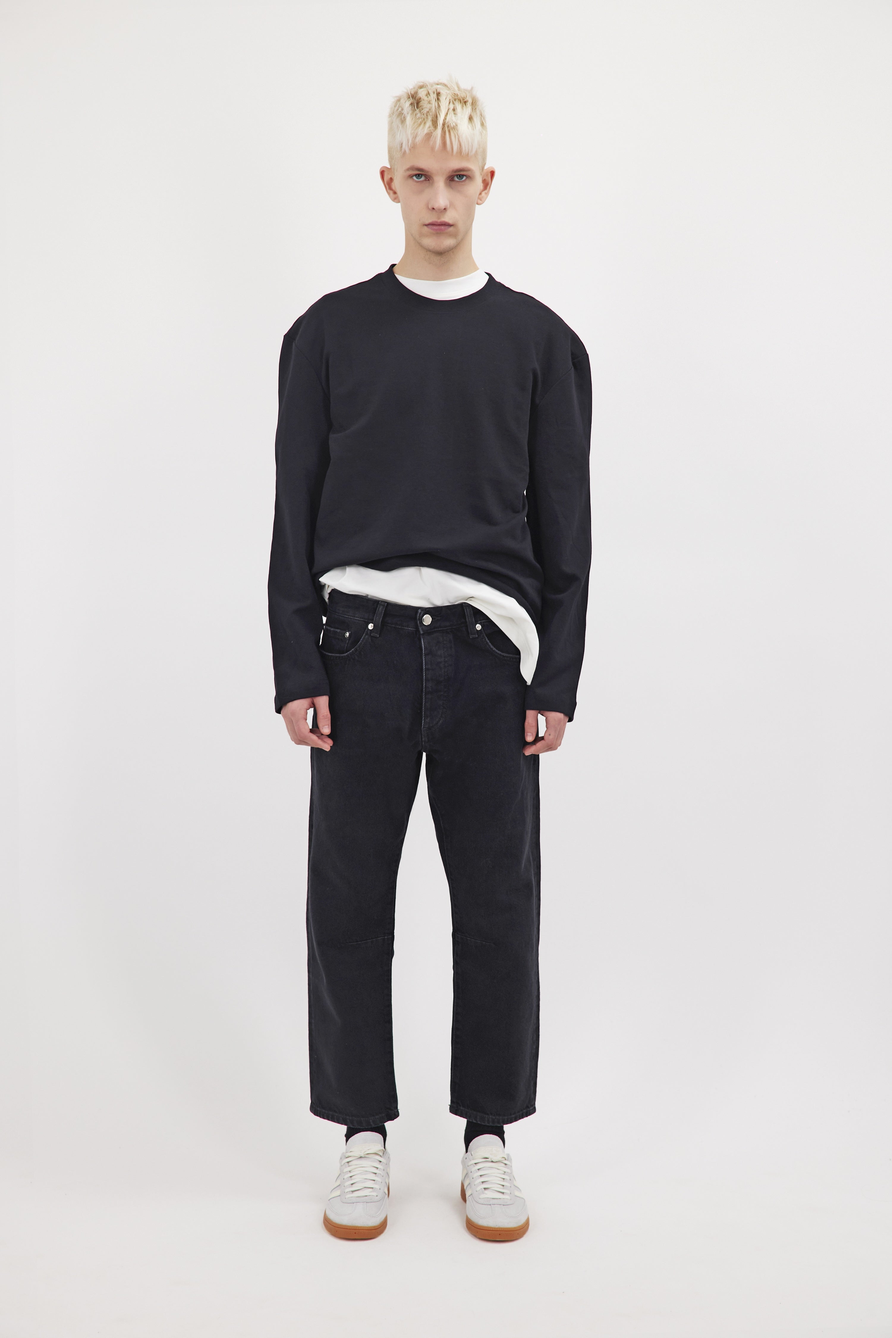 Ash men's baggy-cut jeans in graphite black wash, 100% rigid cotton denim, worn by a model with a black sweatshirt.