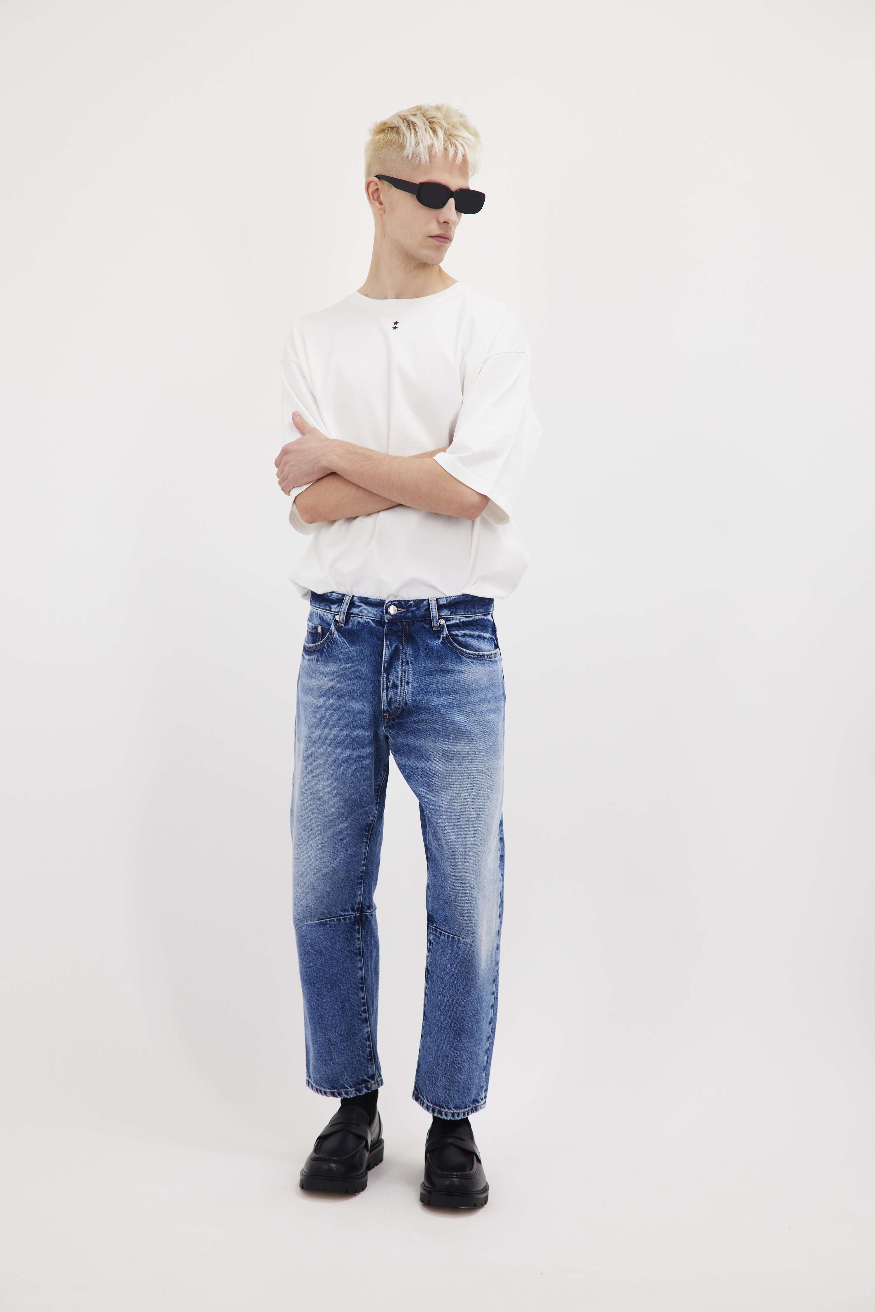 Ash men's baggy-cut jeans in misty blue wash, 100% rigid cotton denim, worn by a model with a white t-shirt.