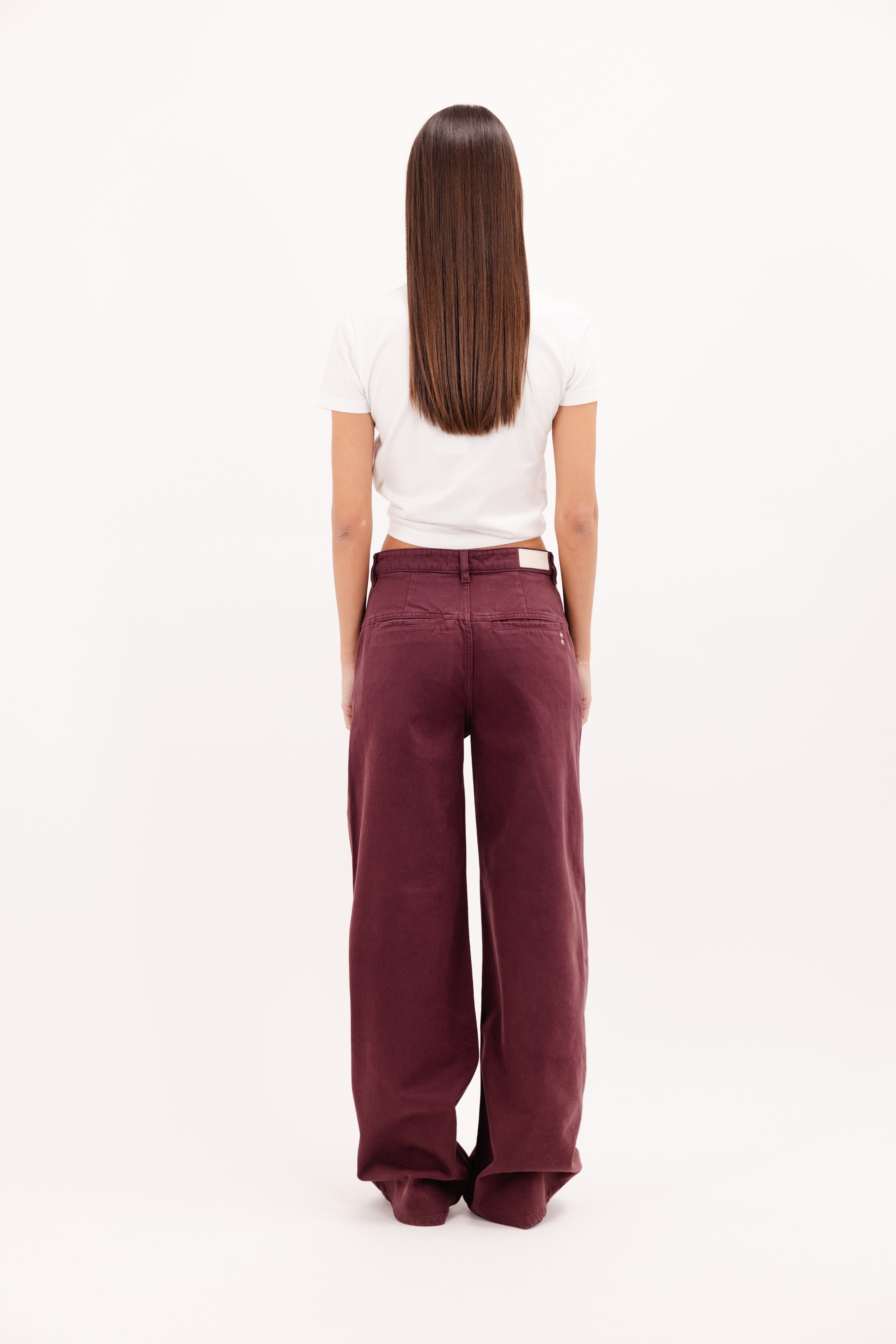 Back view of Ava women’s wide leg jeans in cherry wash, 100% rigid cotton denim, worn by a model with a white t-shirt.