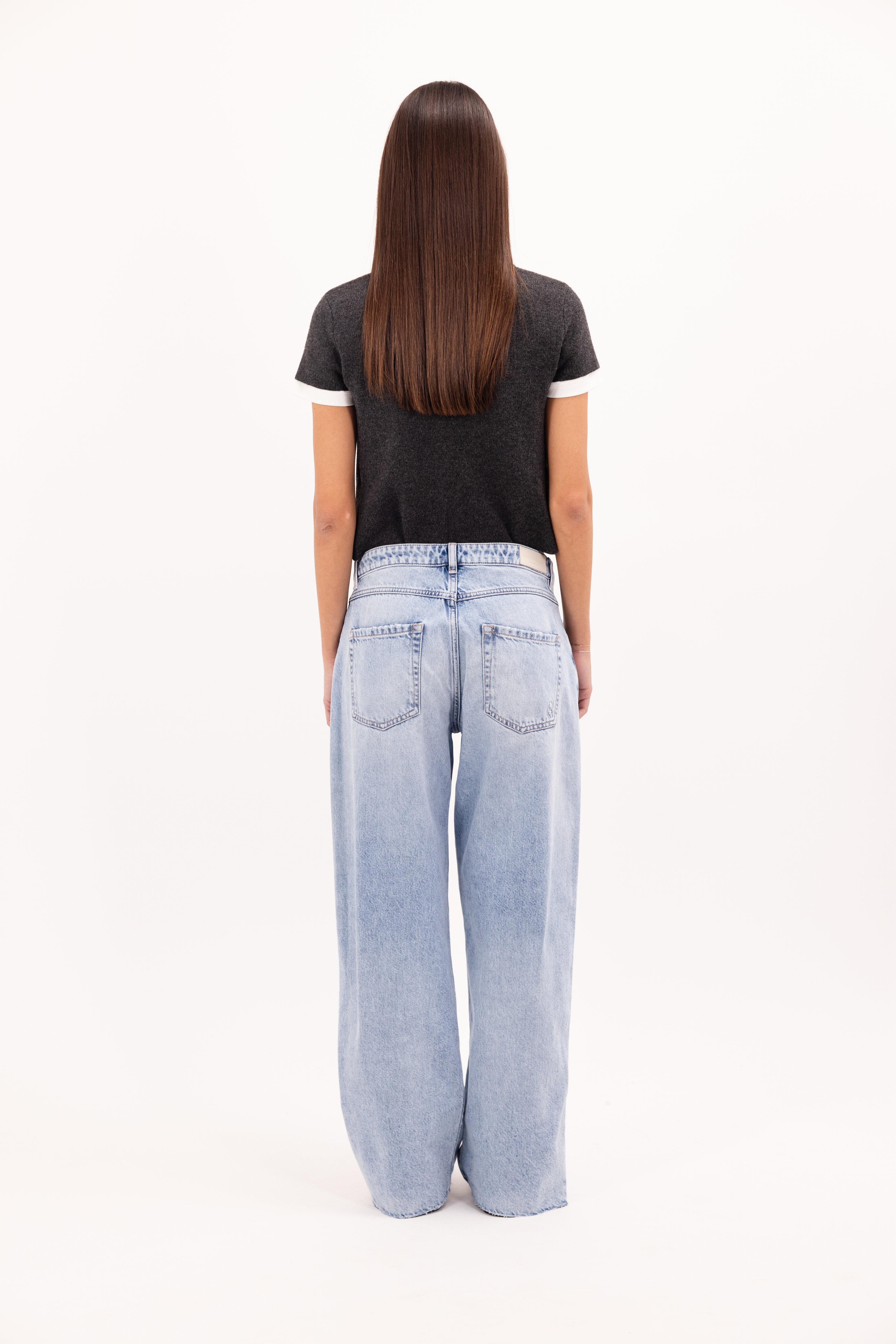 Back view of Bea women’s wide leg jeans in bleached wash, 100% rigid cotton denim, worn by a model with a wool top.