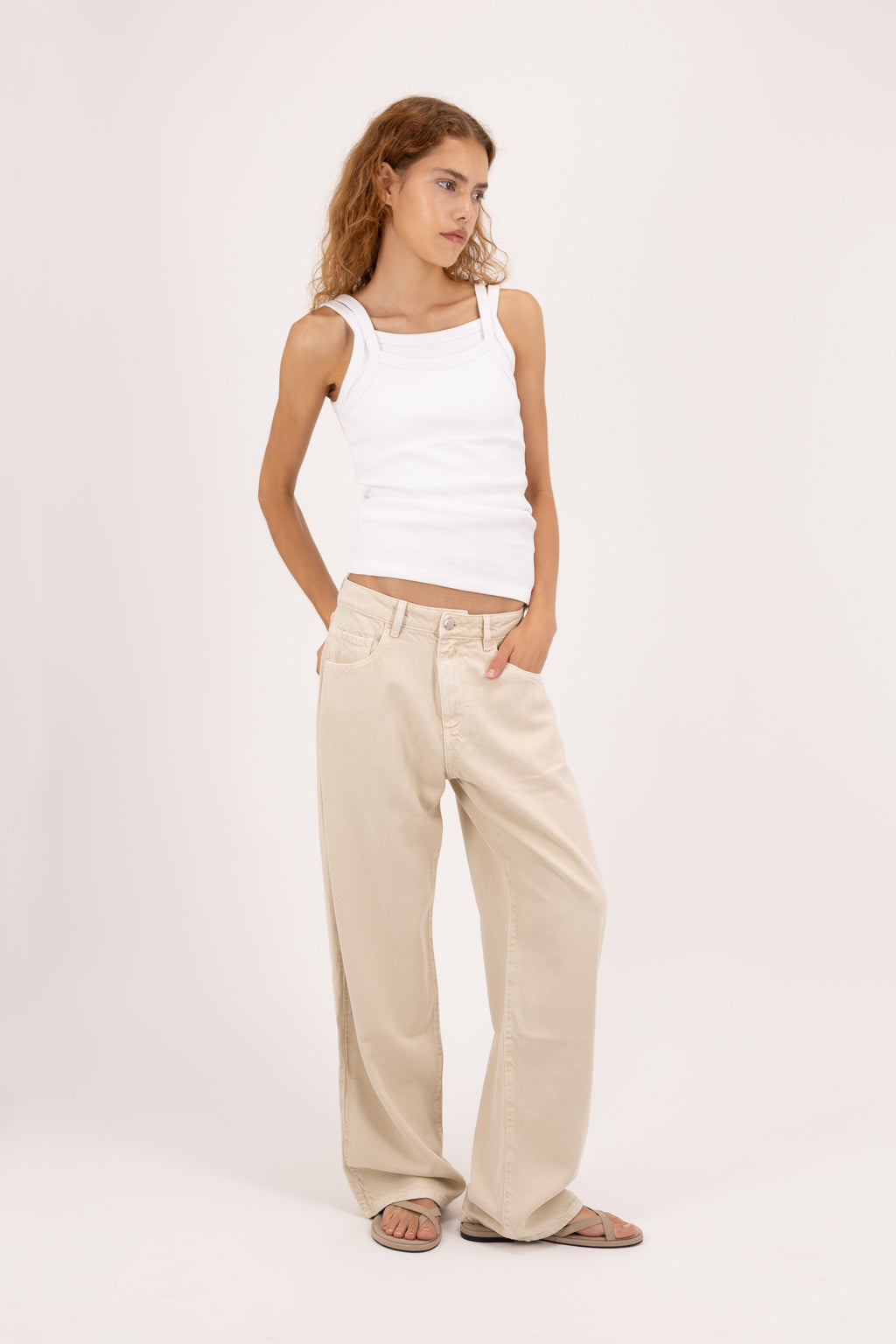 Bea women’s wide leg jeans in desert wash, 100% rigid soft cotton denim, worn by a model with a white tank top.