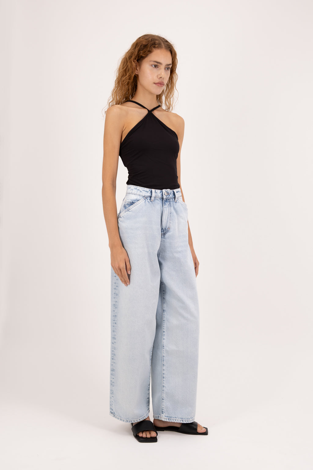 Bess women’s wide leg jeans in bleached wash, 100% rigid cotton denim, worn by a model with a black top.
