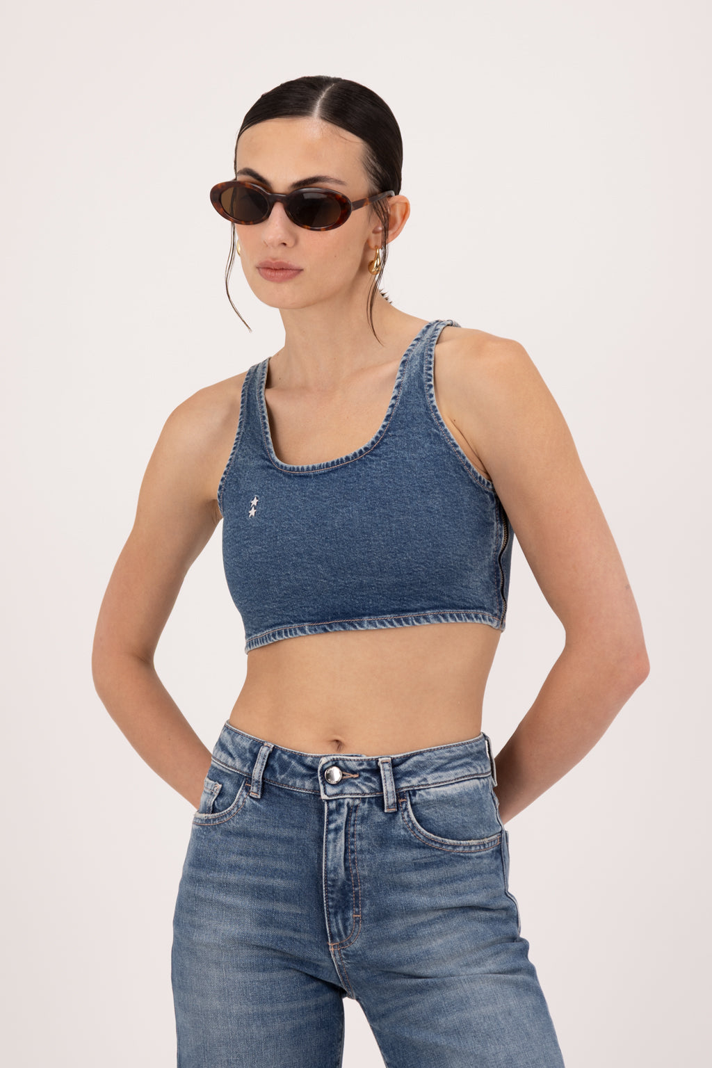 Bibi women’s crop top in dark used wash, 100% rigid cotton denim, worn by a model with jeans.