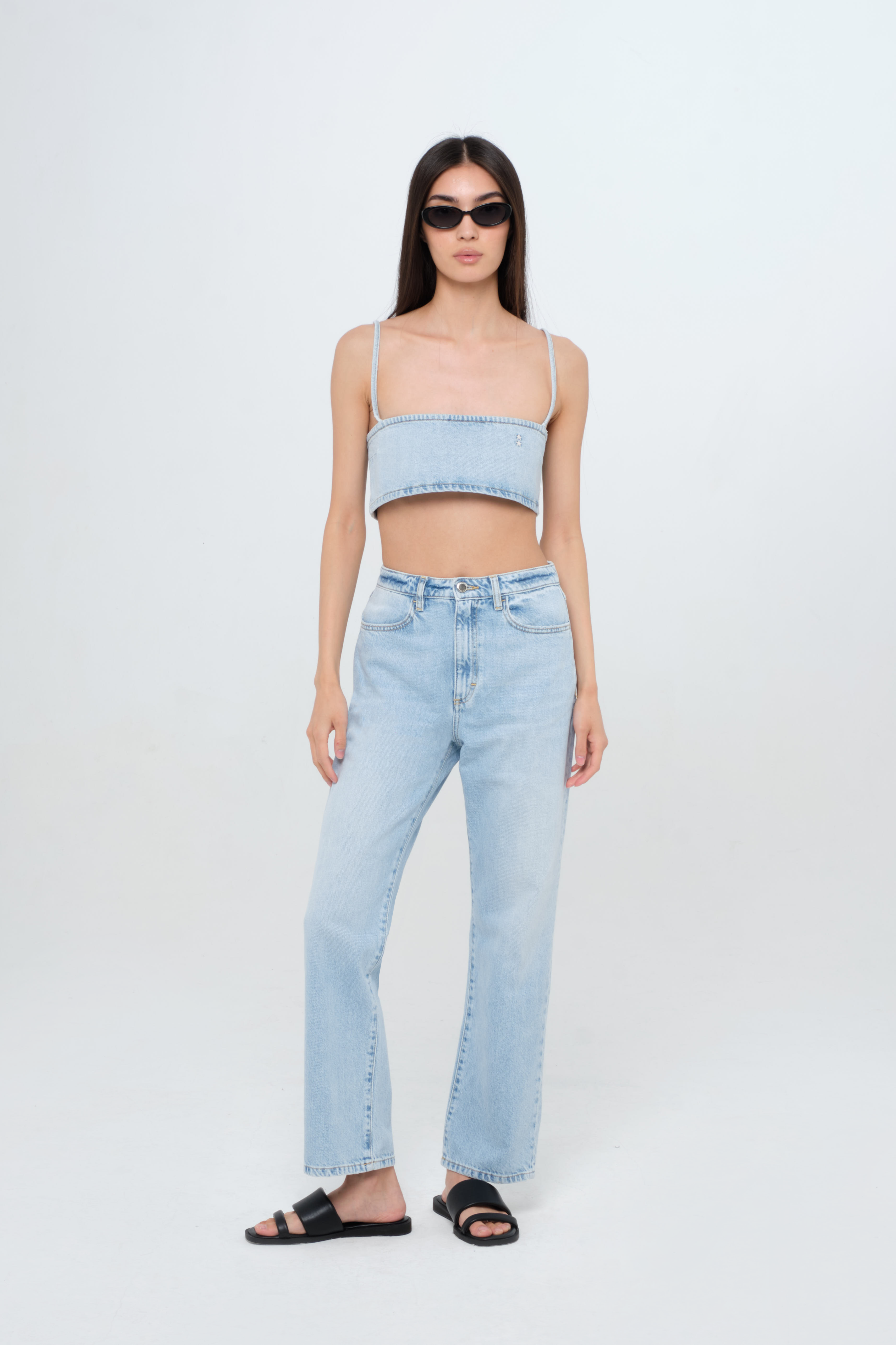 Cady women’s denim crop top  in light wash, 100% rigid cotton denim, worn by a model with jeans.
