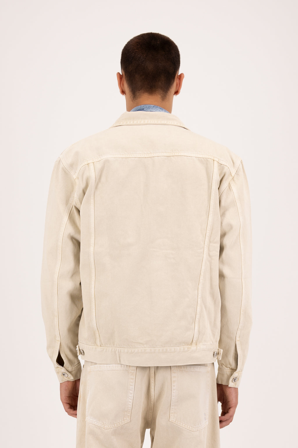 Back view of Cal men’s regular jacket in desert wash, 100% rigid cotton denim, worn by a model with jeans.