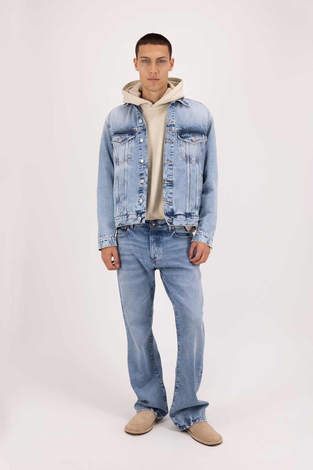 Chad men’s flared leg jeans in river wash, 100% rigid cotton denim, worn by a model with a denim jacket.