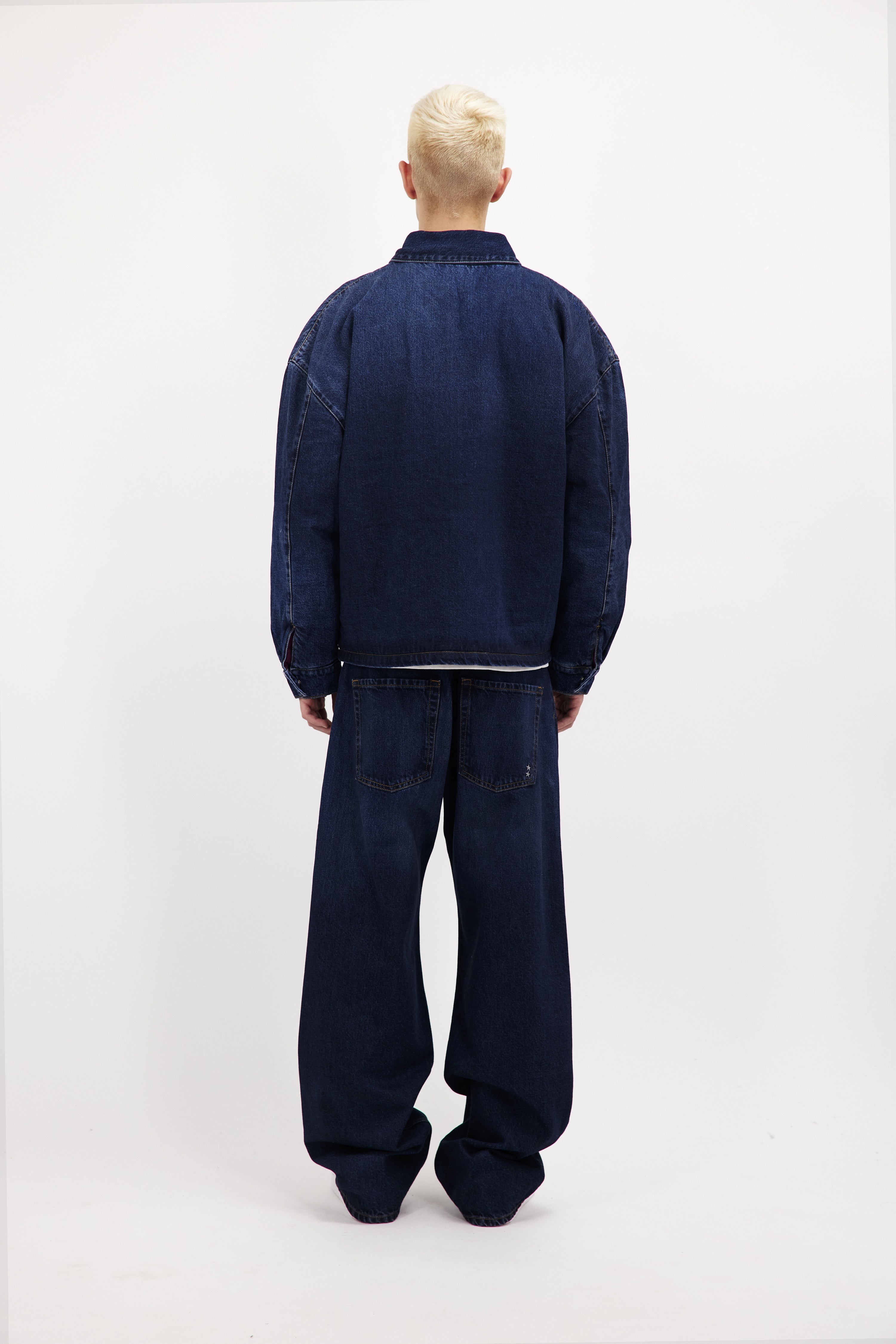 Back view of Chandler men’s jacket in dusty blue wash, 100% rigid cotton denim, worn by a model with jeans.