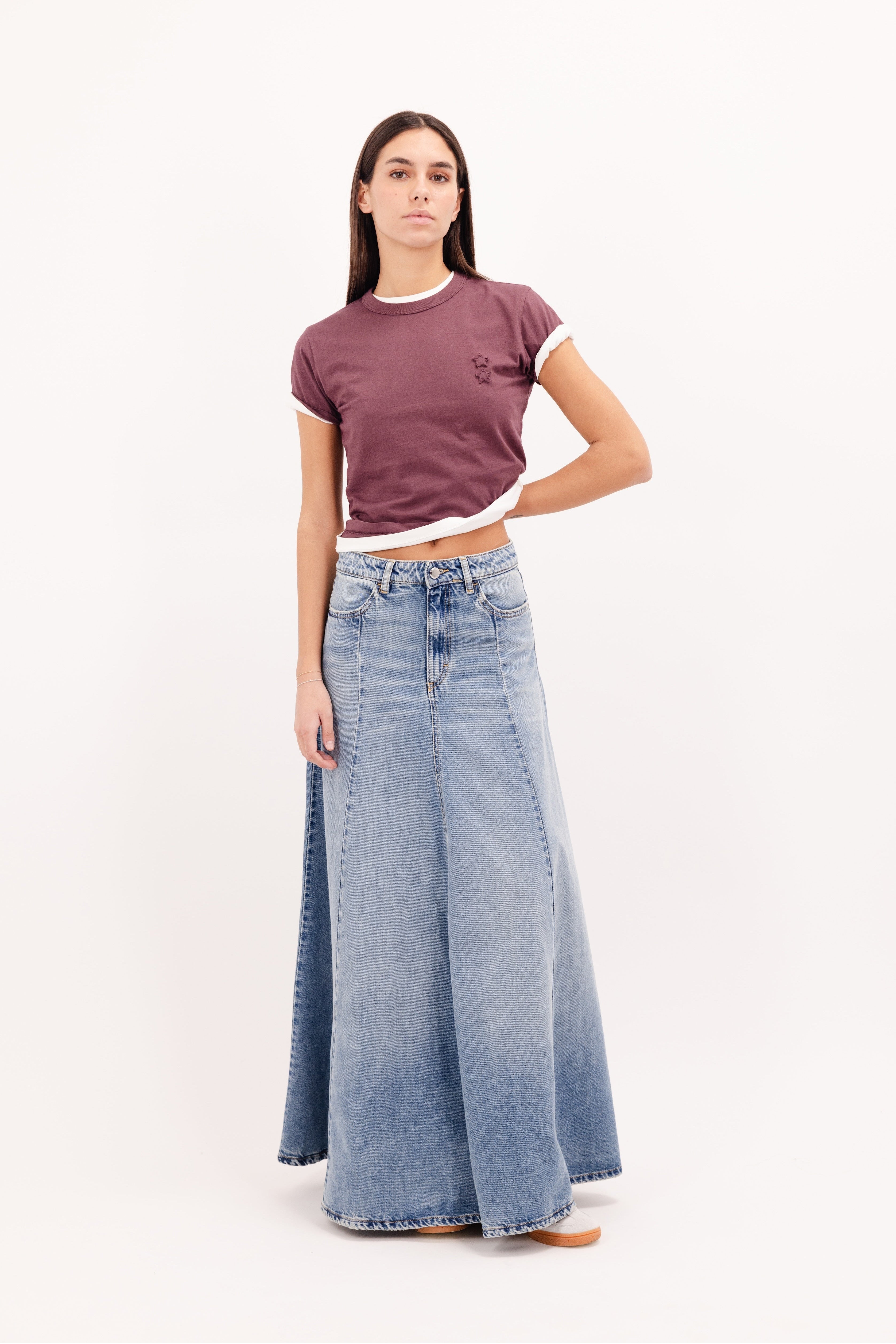 Cora women’s long skirt in smoke blue wash, 100% rigid cotton denim, worn by a model with a cherry t-shirt.