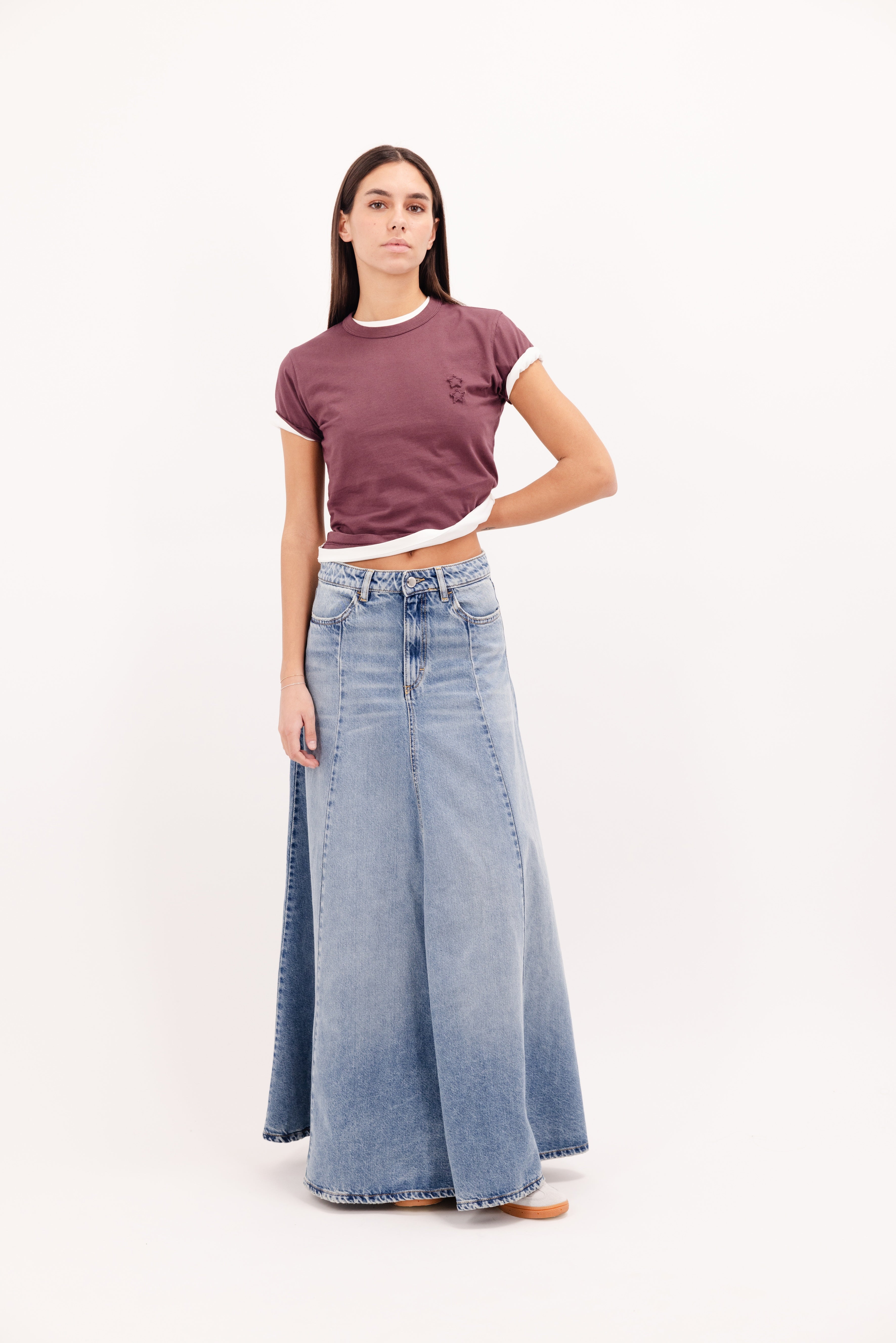 Cora women’s long skirt in smoke blue wash, 100% rigid cotton denim, worn by a model with a cherry t-shirt.