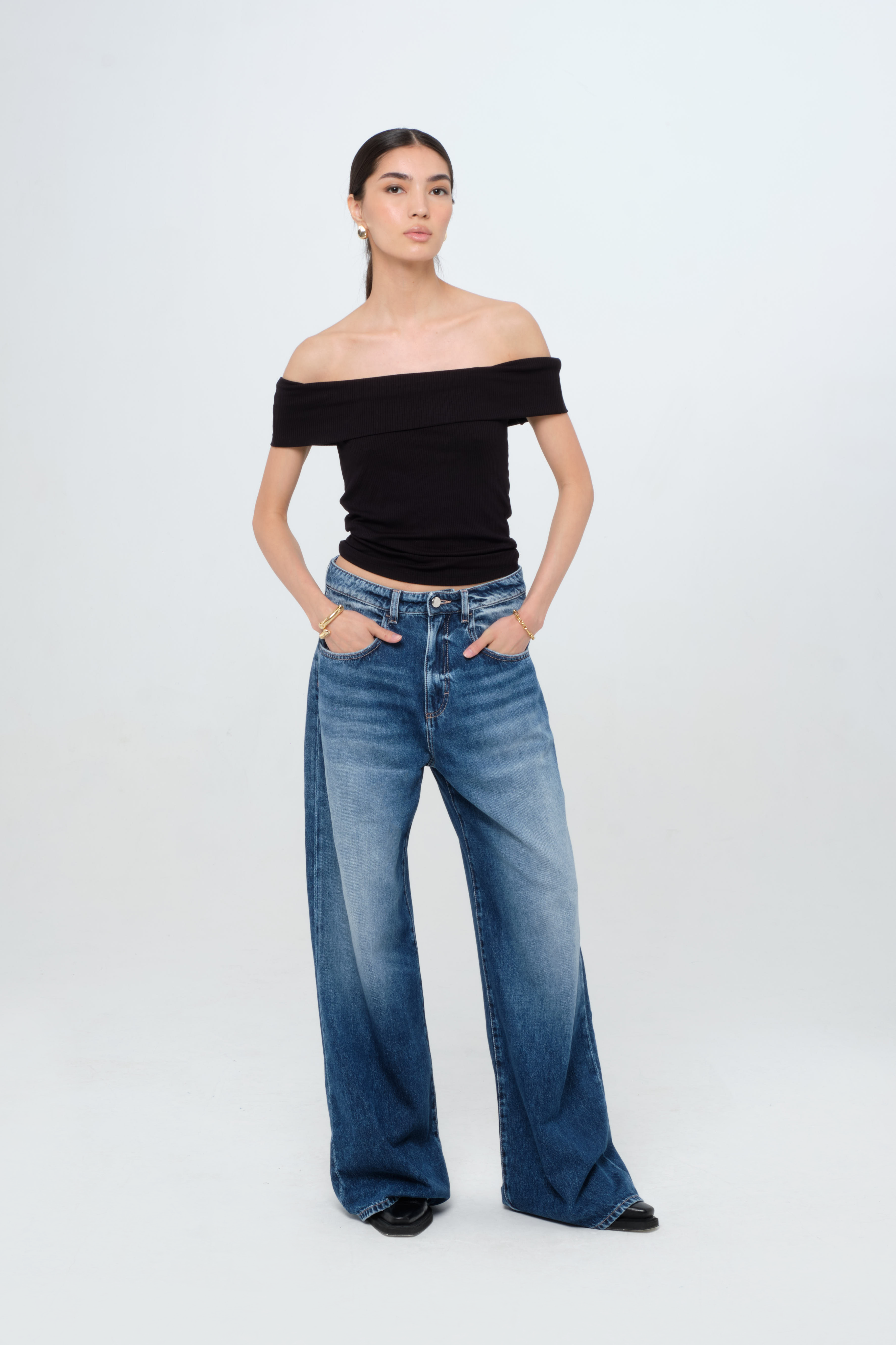 Debby women’s wide leg jeans in dark wash, 100% rigid cotton denim, worn by a model with a black top.
