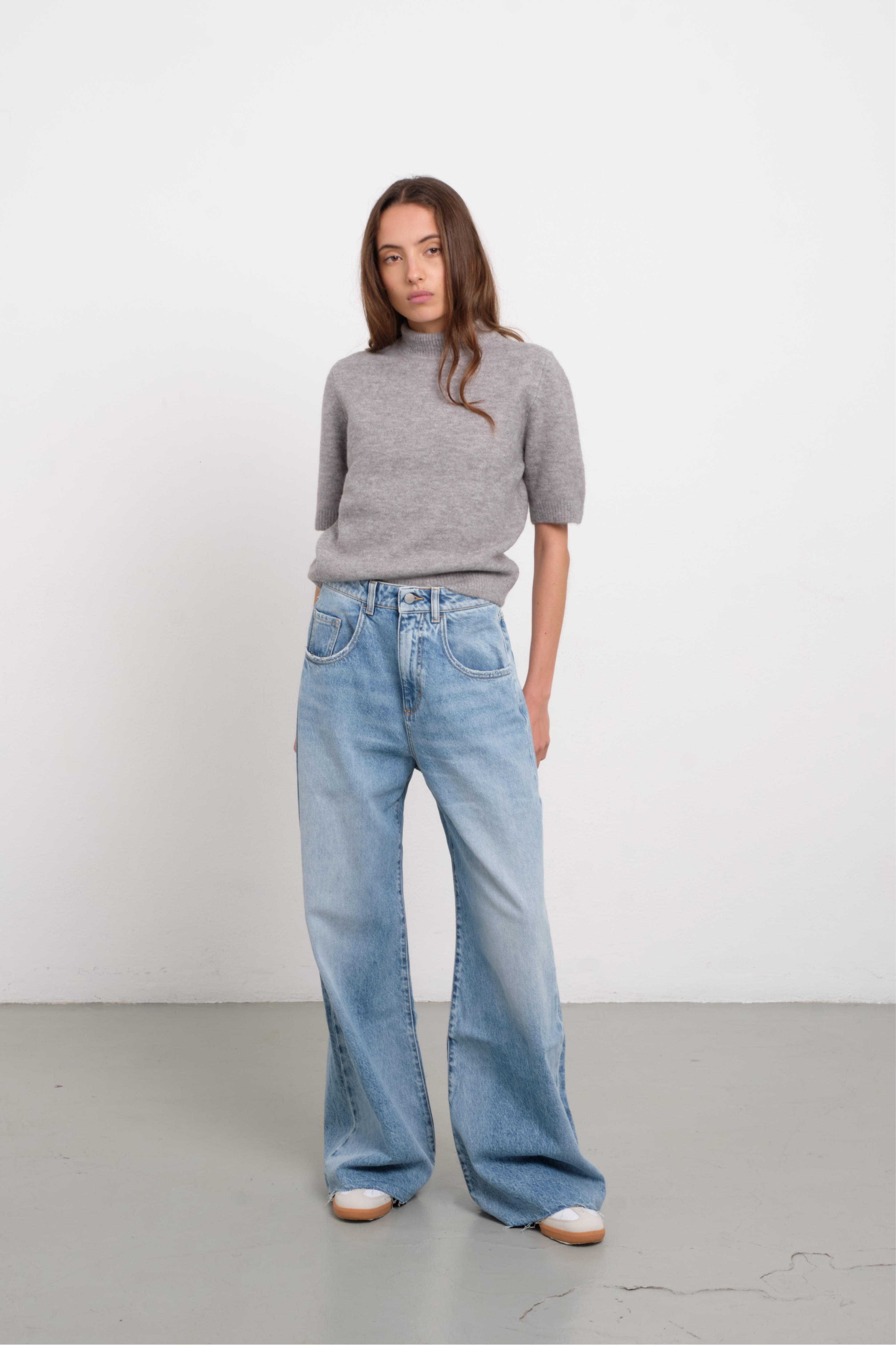Debby women’s wide leg jeans in light wash, 100% rigid cotton denim, worn by a model with a gray shirt.
