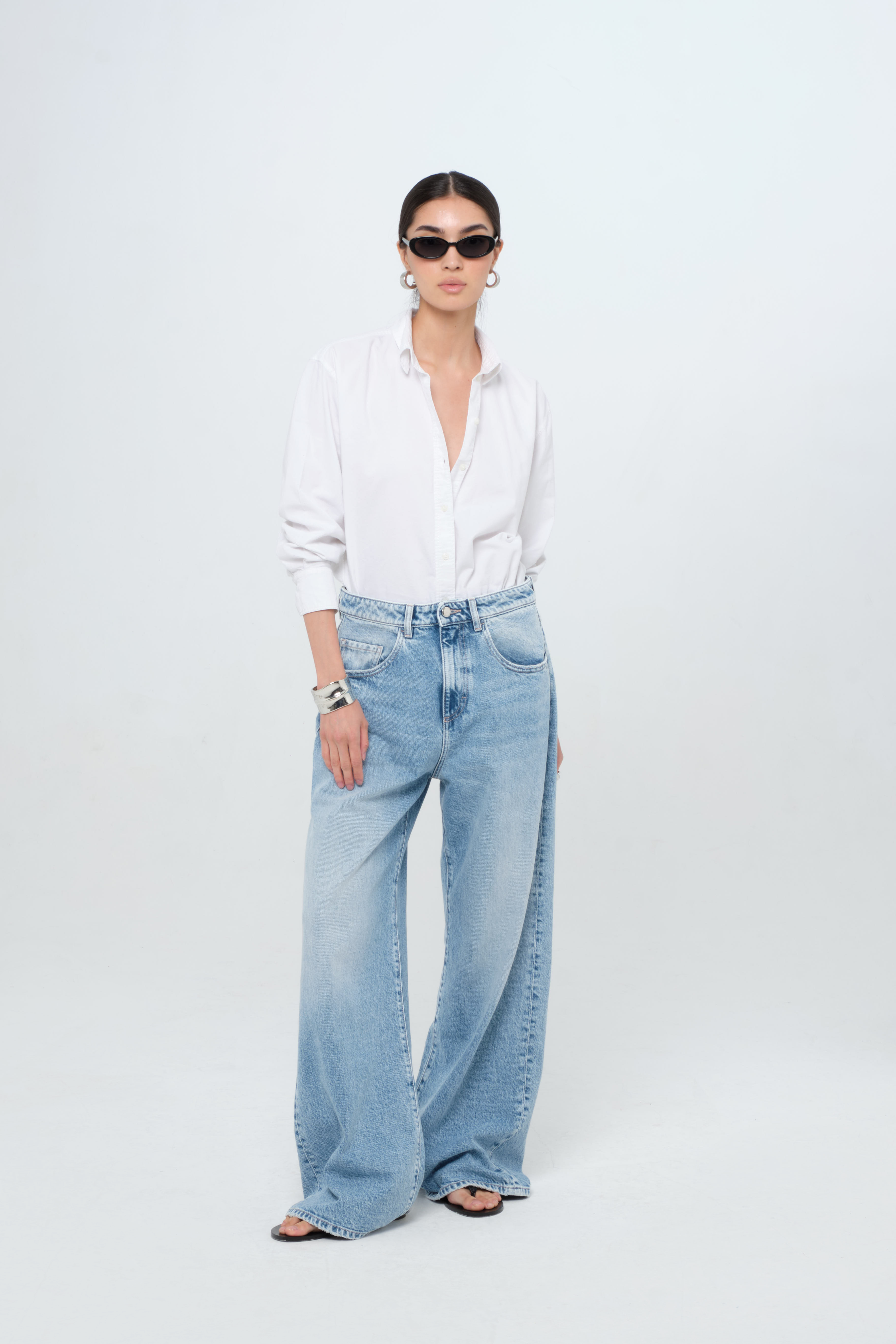 Debby women’s wide leg jeans in light wash, 100% rigid cotton denim, worn by a model with a white shirt.