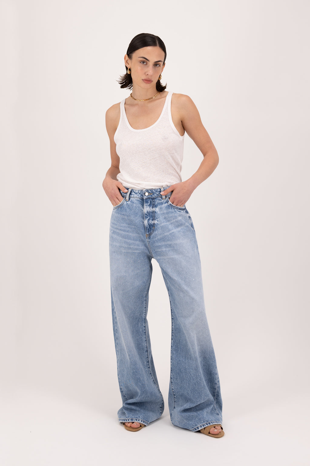 Debby women’s wide leg jeans in river wash, 100% rigid cotton denim, worn by a model with a white tank top.