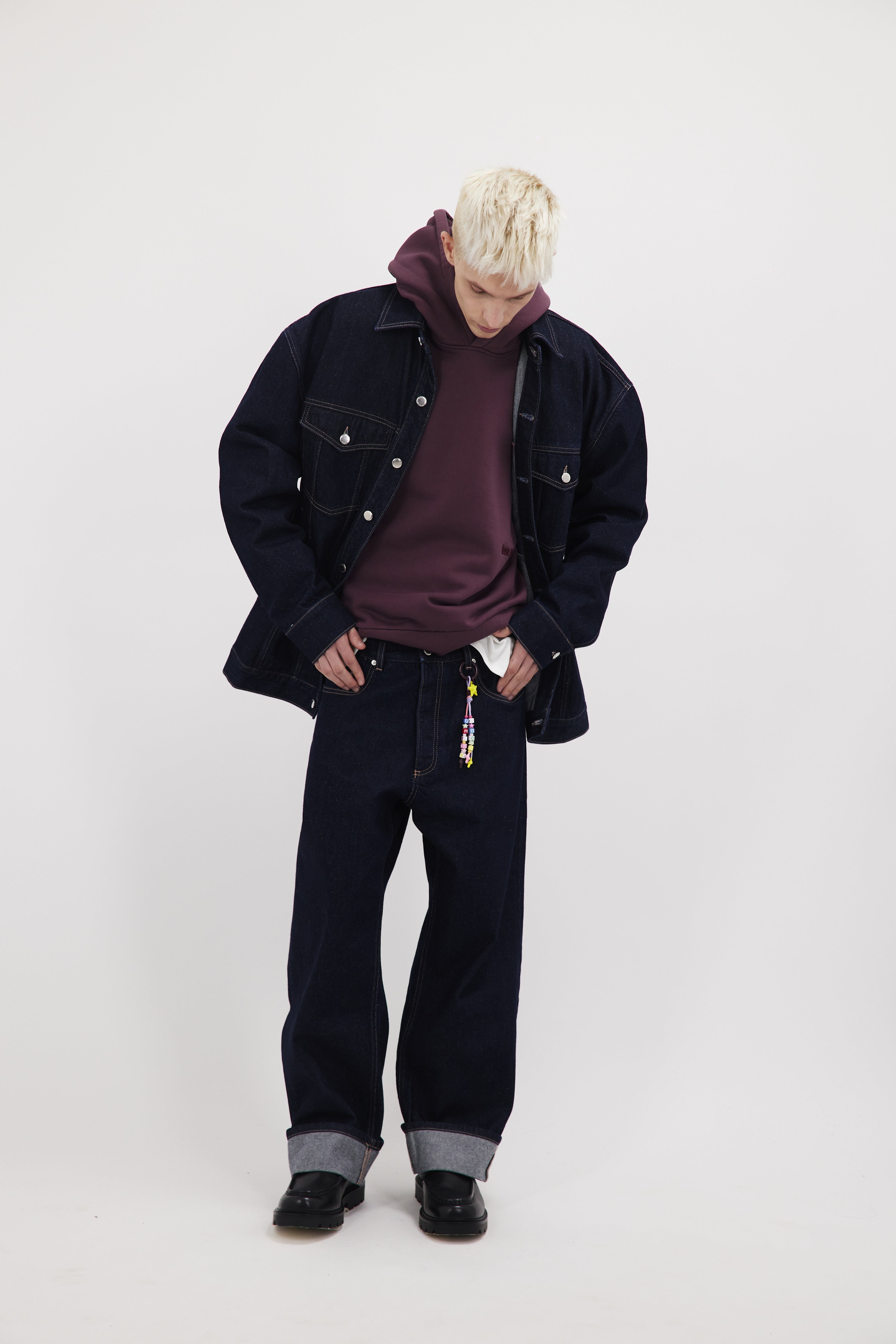 Drew men’s oversize jacket in indigo raw, 100% rigid cotton denim, worn by a model with jeans.