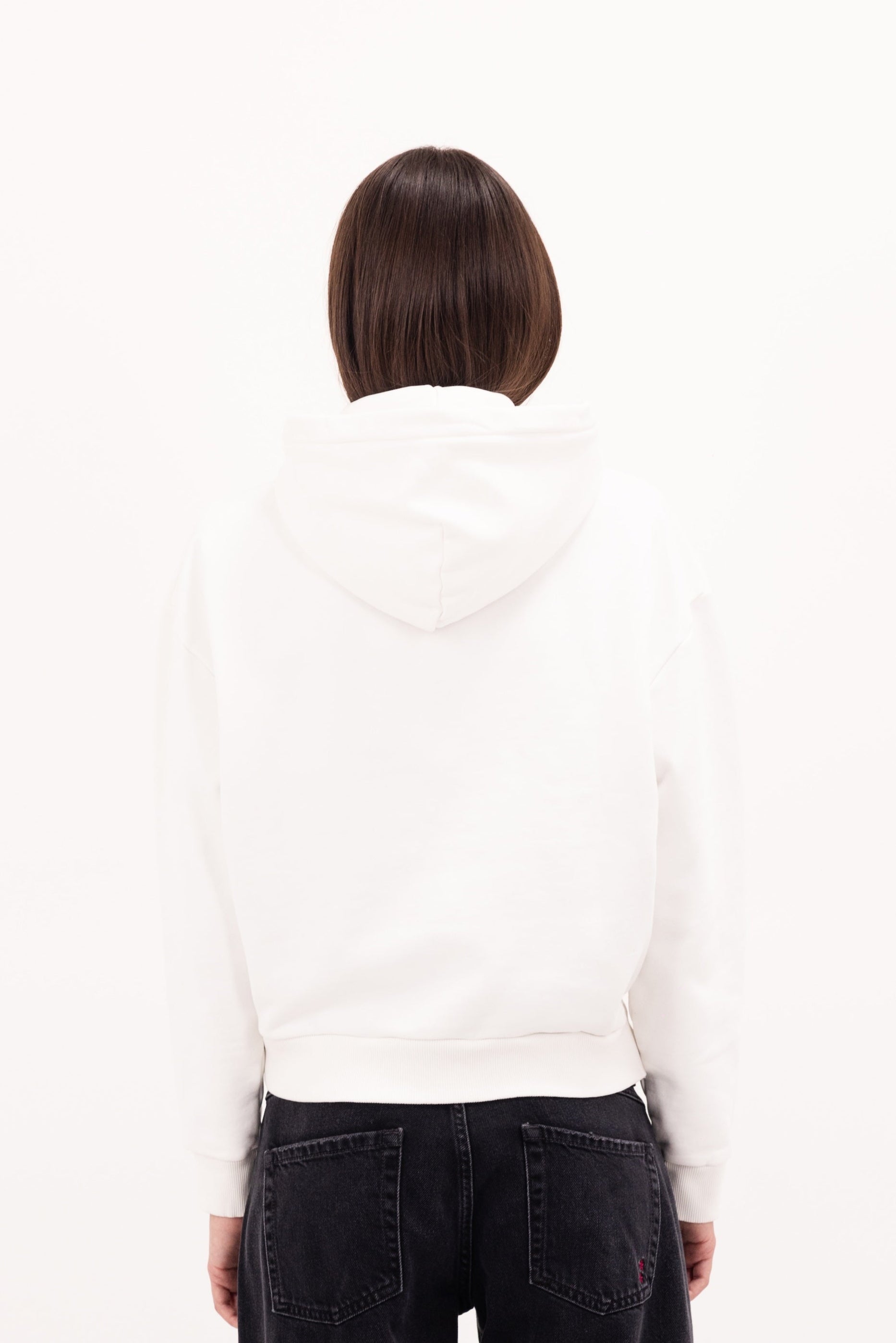 Back view of Ebbie women’s hoodie in white, 100% cotton, worn by a model.