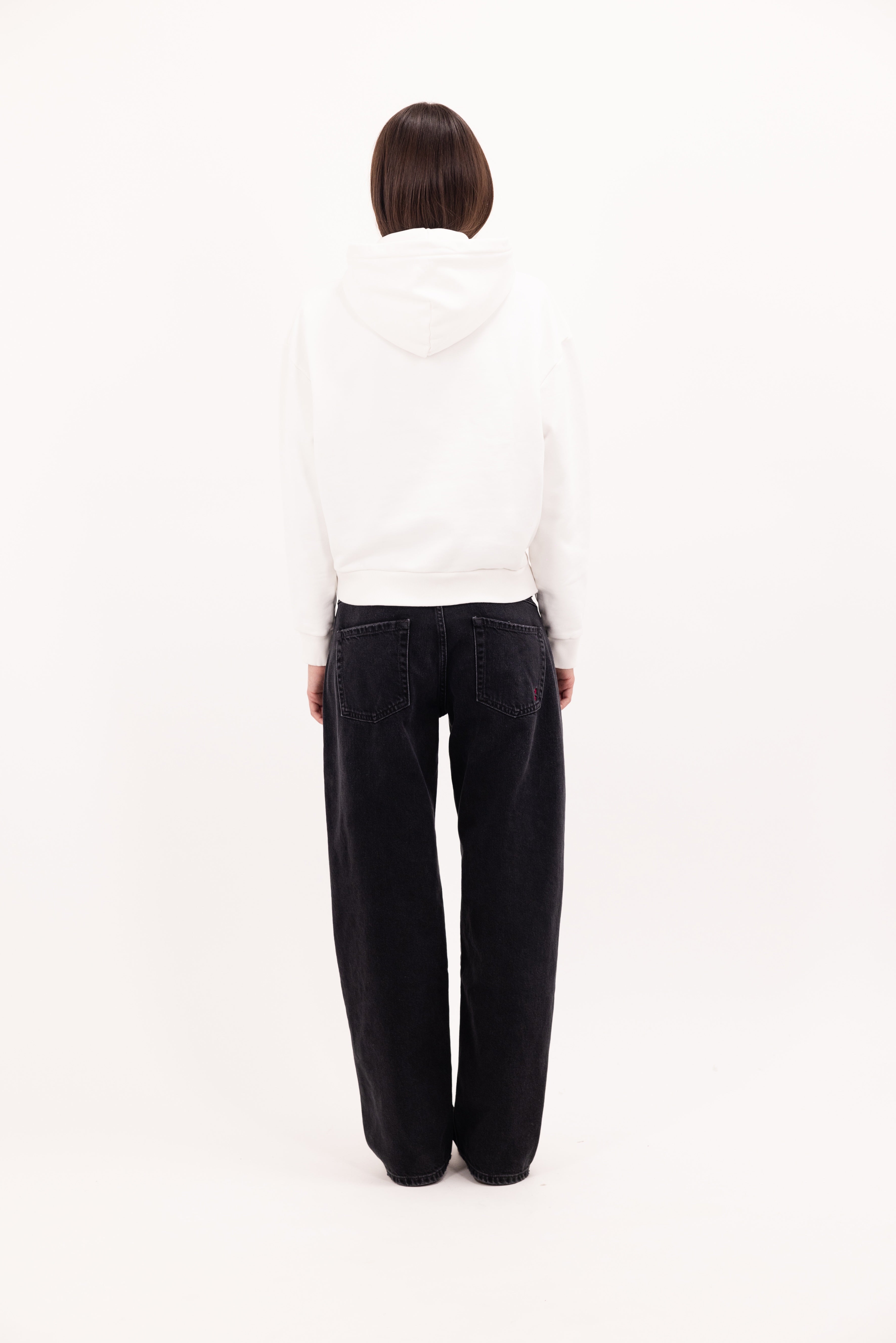 Back view of Ebbie women’s hoodie in white, 100% cotton, worn by a model.