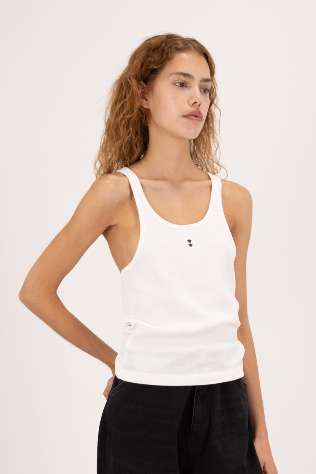 Emily women’s tank top in white, 100% cotton, worn by a model with jeans.
