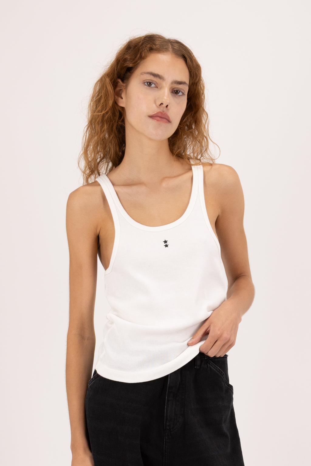Emily women’s tank top in white, 100% cotton, worn by a model with jeans.