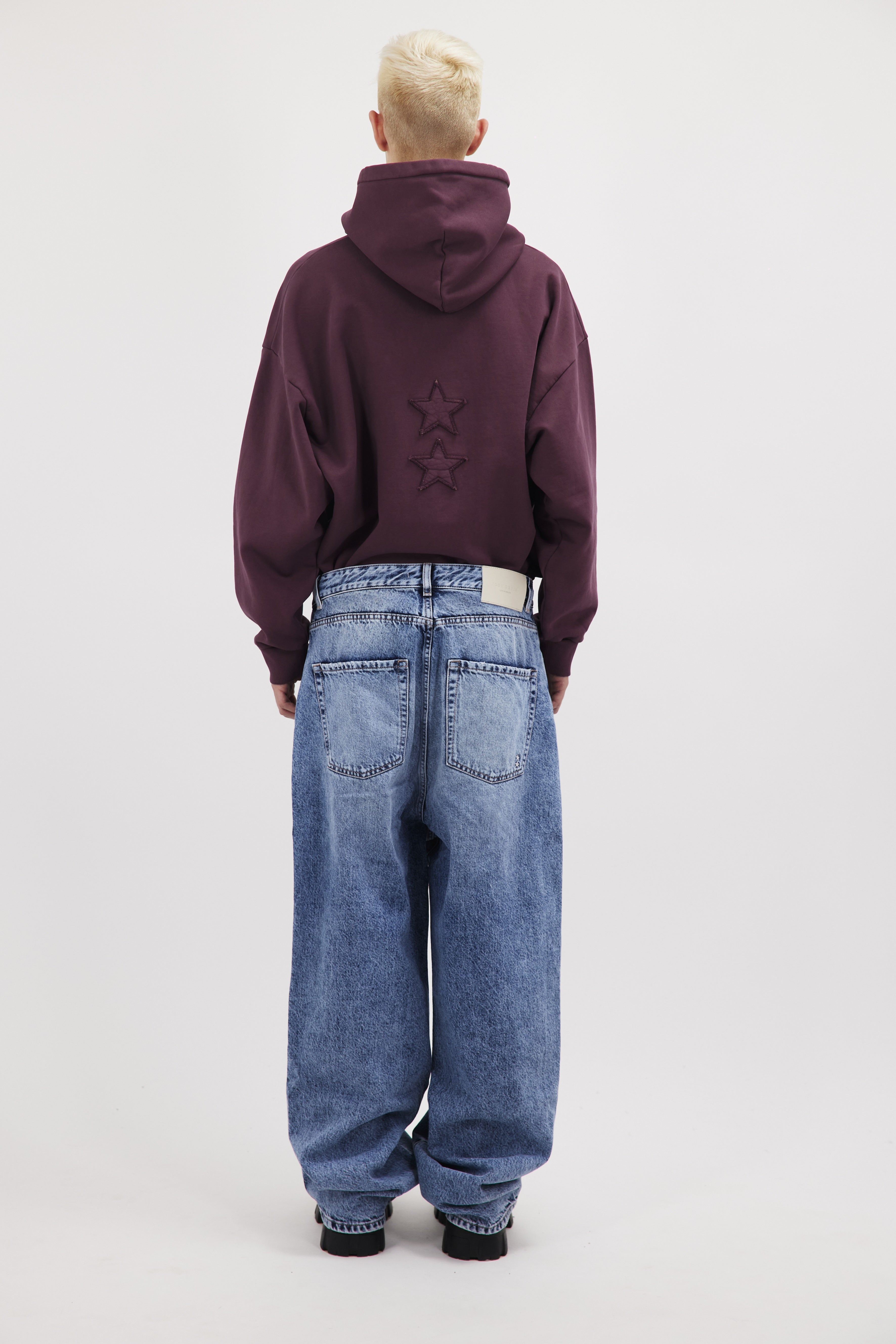 Back view of Gab men’s wide leg jeans in misty blue wash, 100% rigid cotton denim, worn by a model with a cherry sweatshirt.