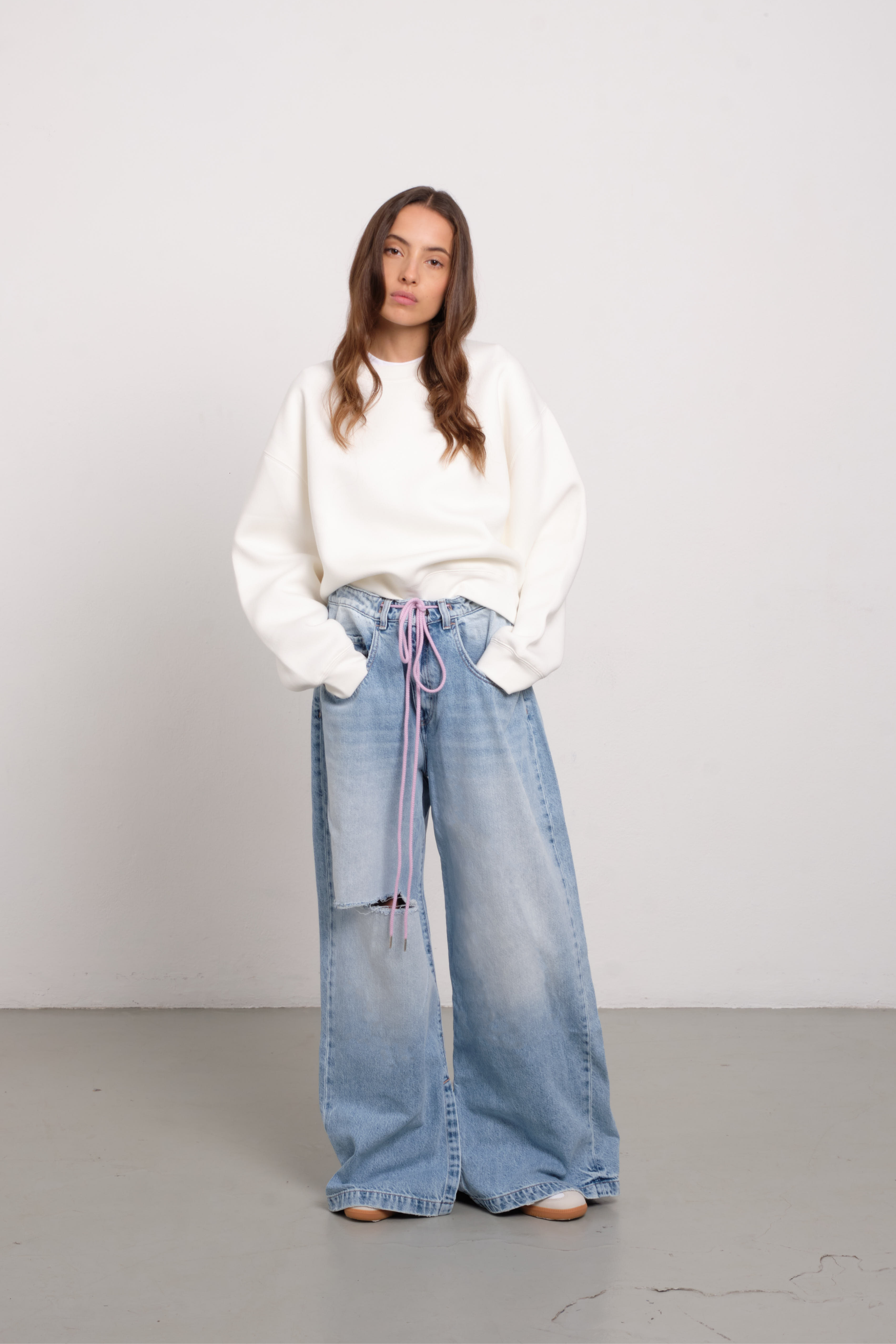 Gracy women’s wide leg jeans in light wash, 100% rigid cotton denim, worn by a model with a white hoodie.