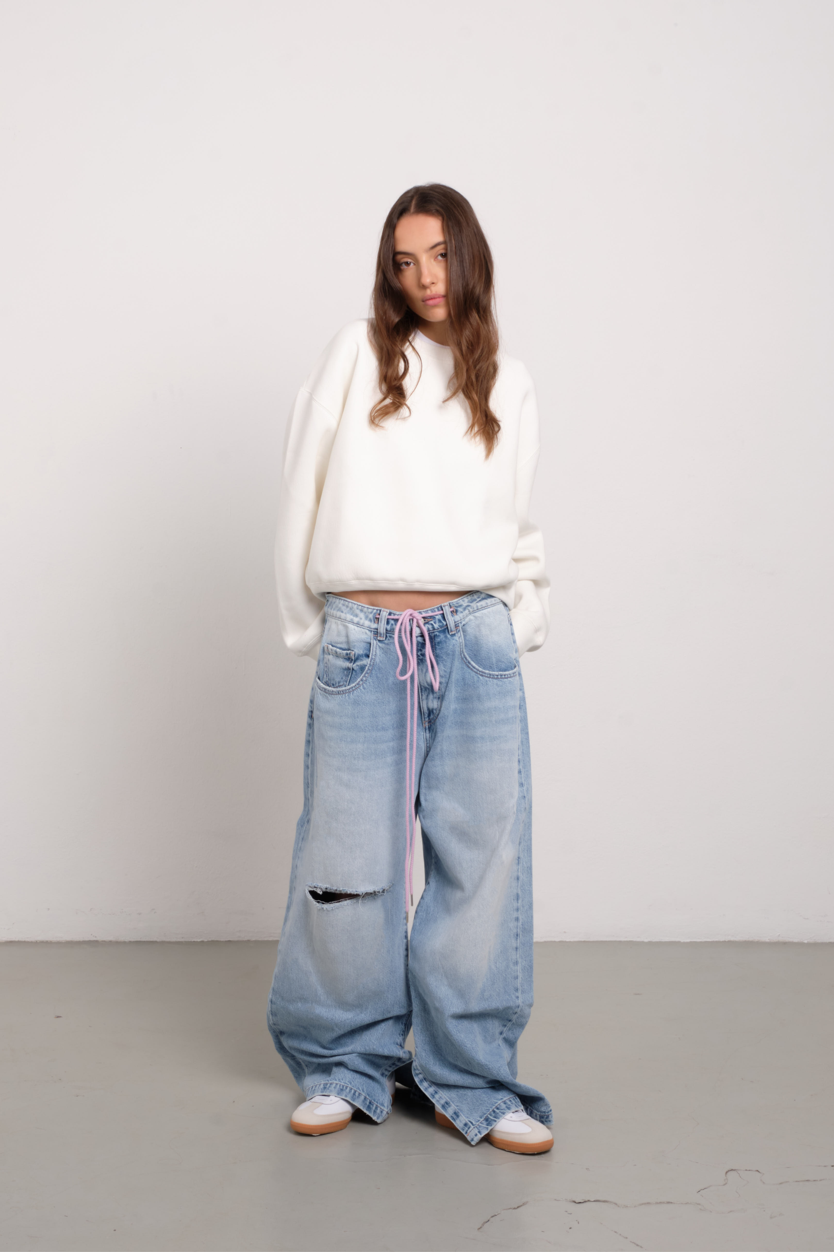 Gracy women’s wide leg jeans in light wash, 100% rigid soft cotton denim, worn by a model with a white hoodie.