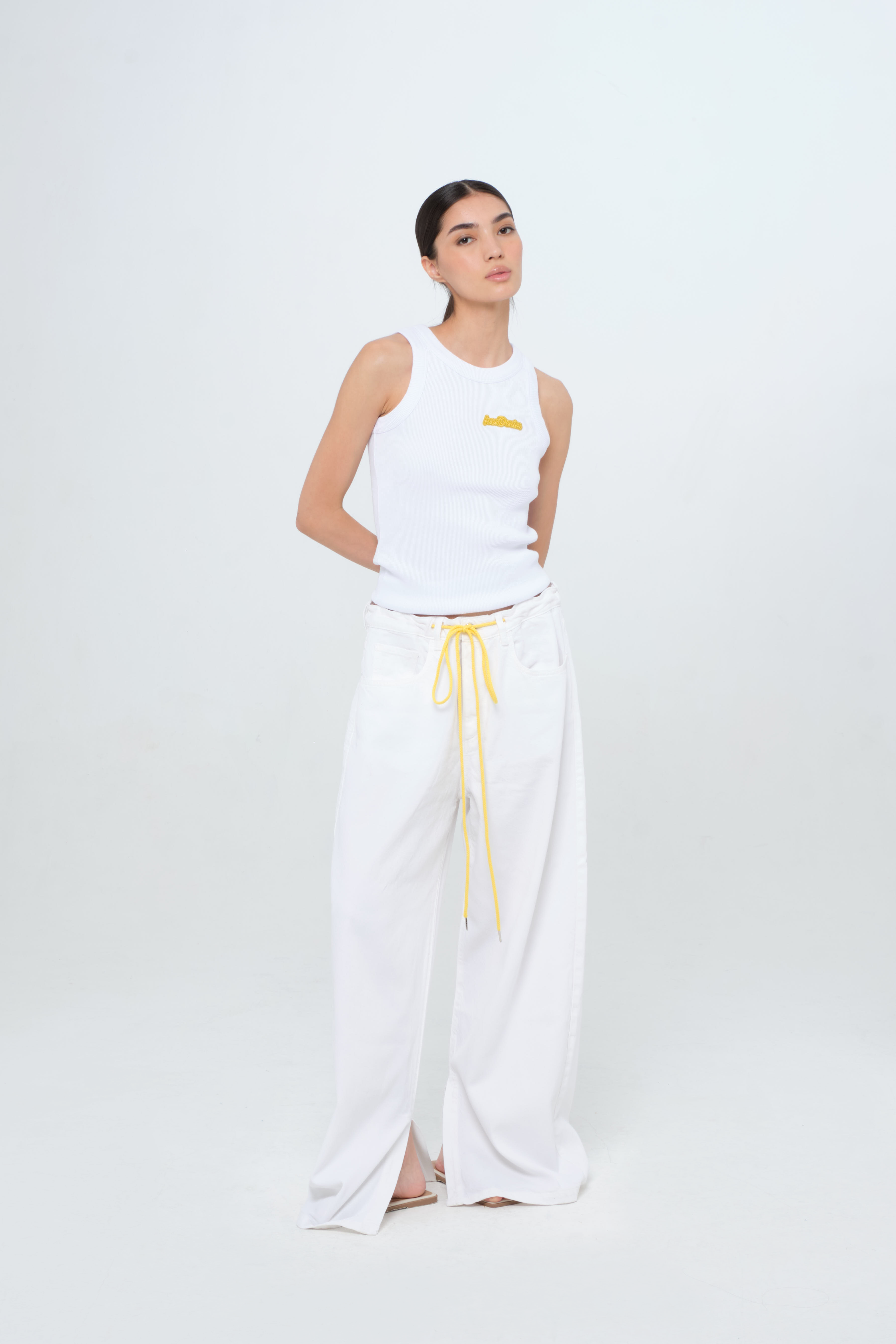 Gracy women’s wide leg jeans in white, 100% rigid soft cotton denim, worn by a model with a white tank top.
