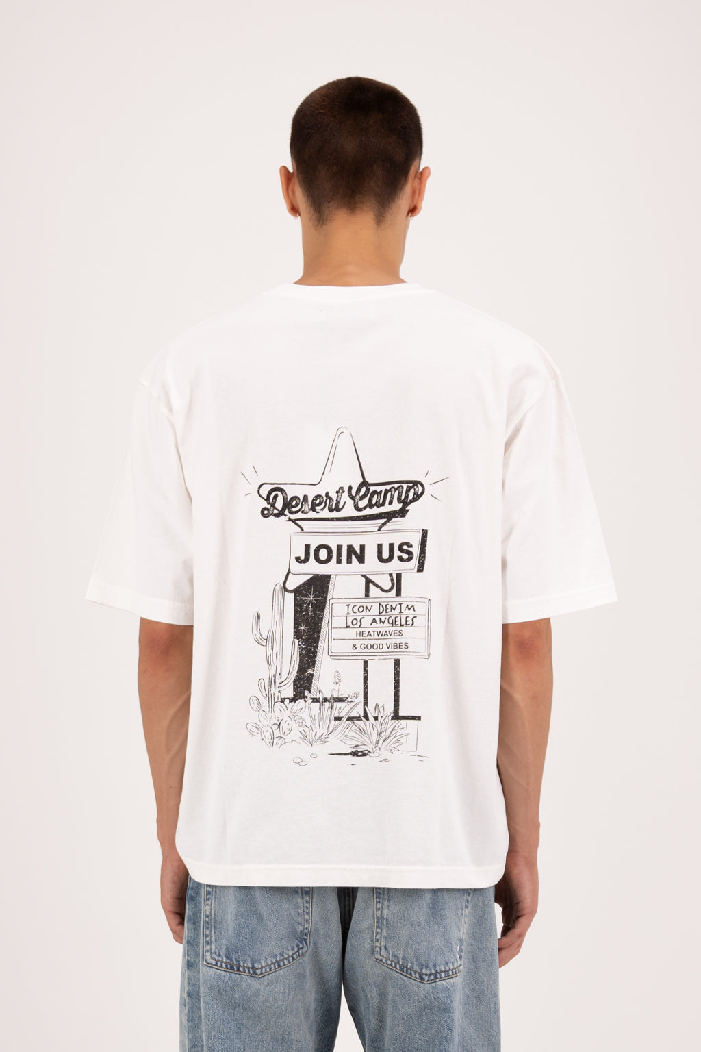 Back view of Haak men’s t-shirt in white, 100% cotton, worn by a model with jeans.