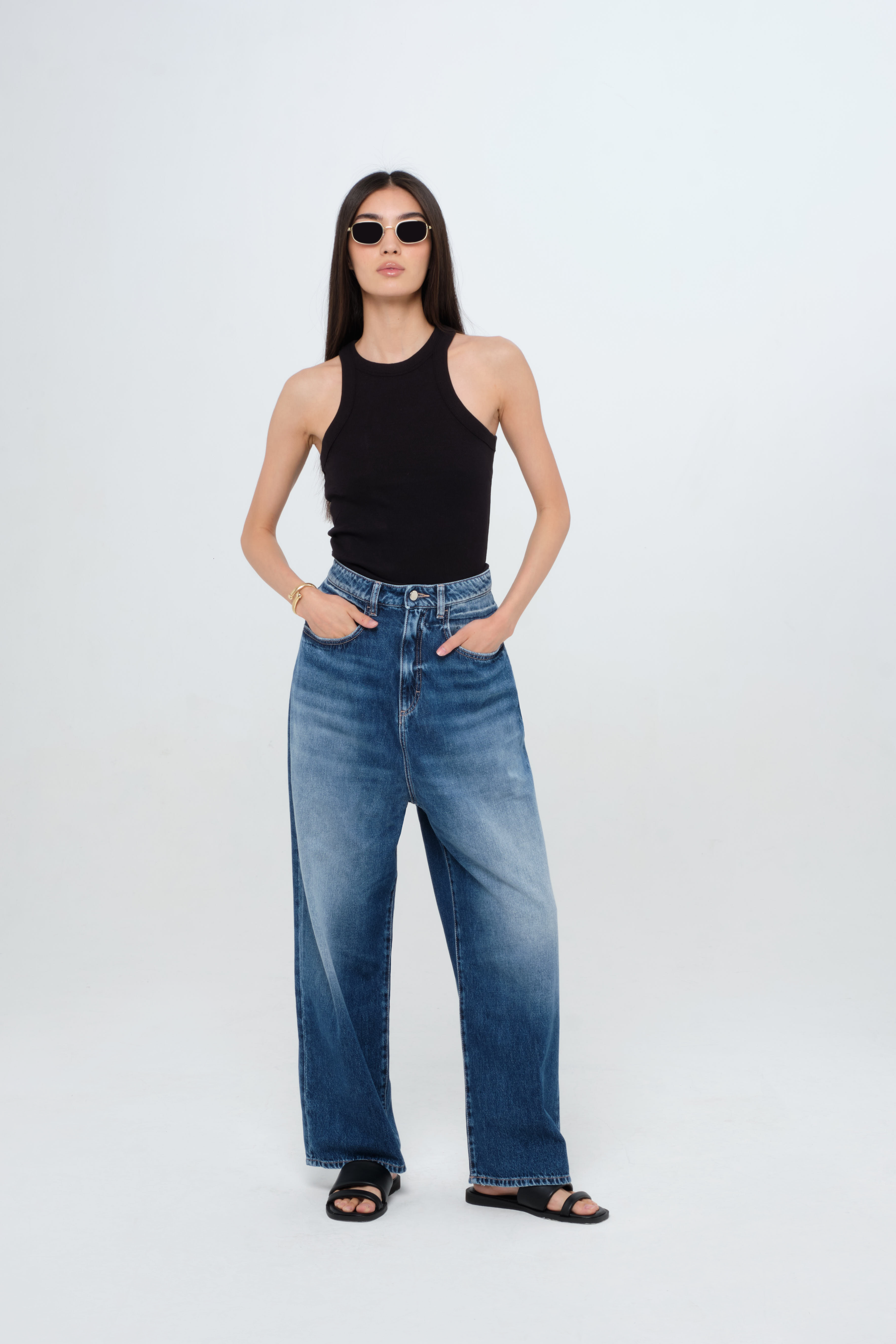 Holly women’s wide leg jeans in medium wash, 100% rigid cotton denim, worn by a model with a black tank top.

