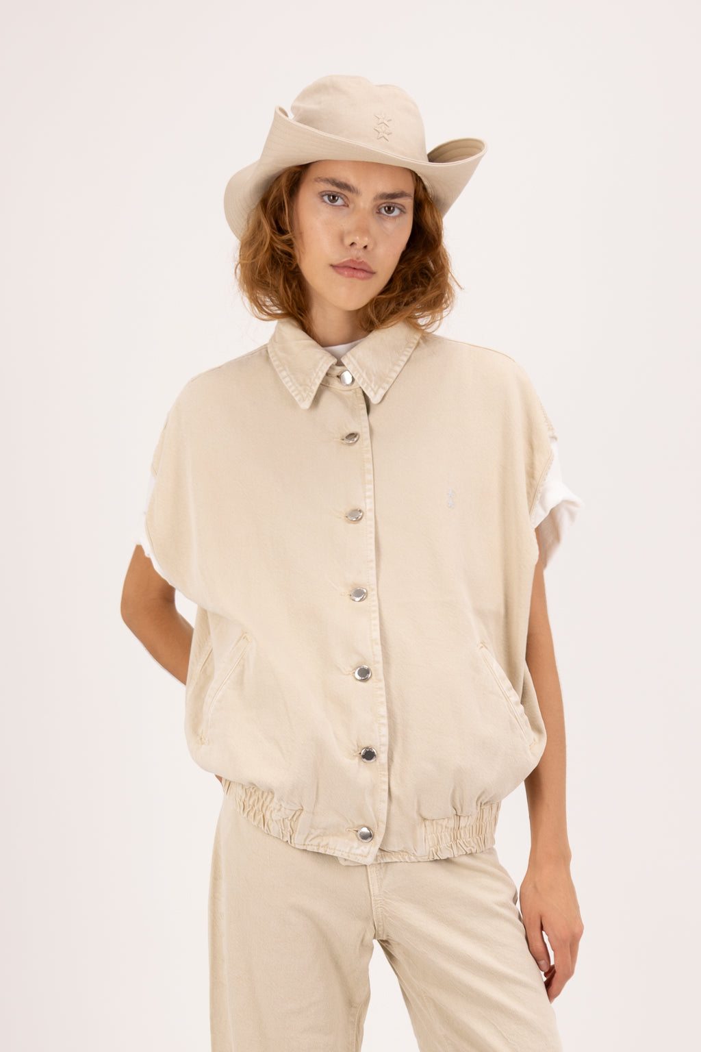 Ines women’s vest in desert wash, 100% rigid soft cotton denim, worn by a model with jeans.