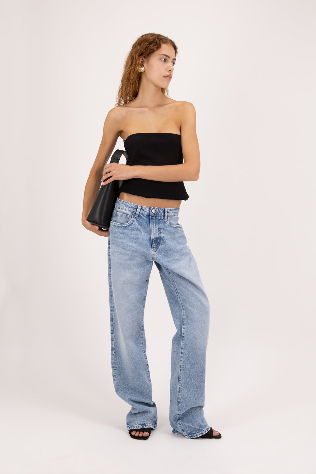 Iris Eco women’s wide leg jeans in arid blue wash, 100% organic rigid cotton denim, worn by a model with a black top.