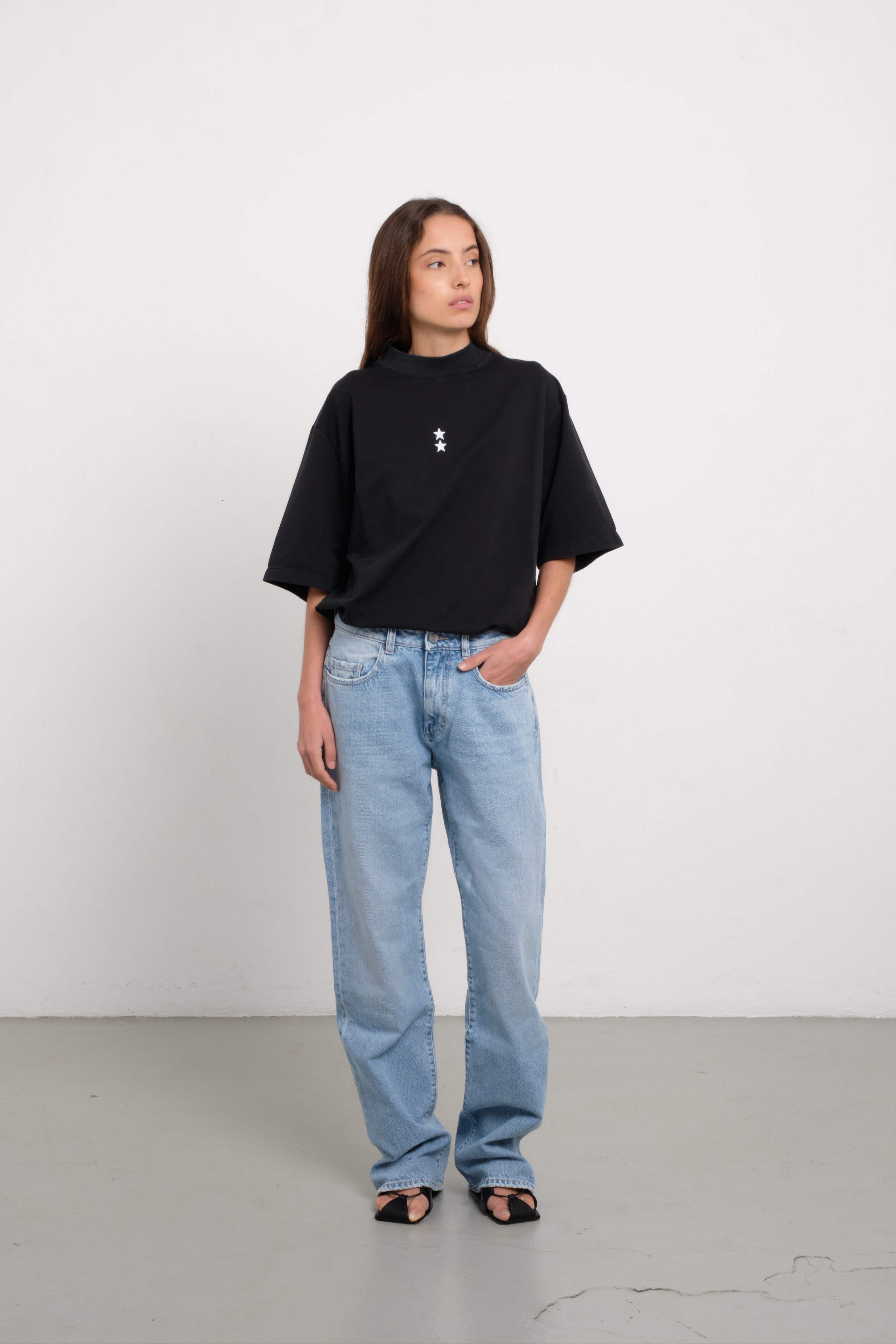 Iris women’s wide leg jeans in light wash, 100% rigid cotton denim, worn by a model with a black shirt.
