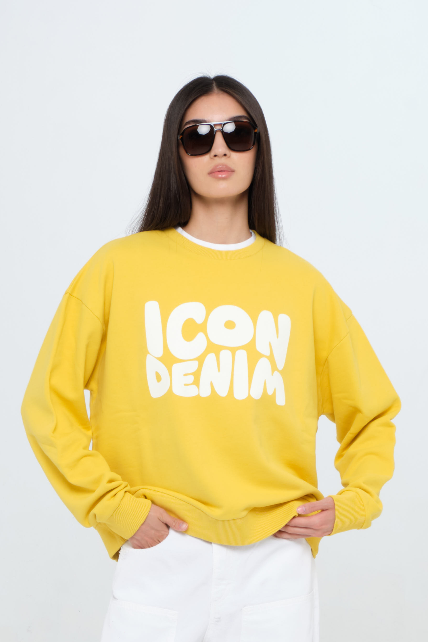 Jamie women’s sweatshirt in sunny, 100% cotton, worn by a model with white jeans.
