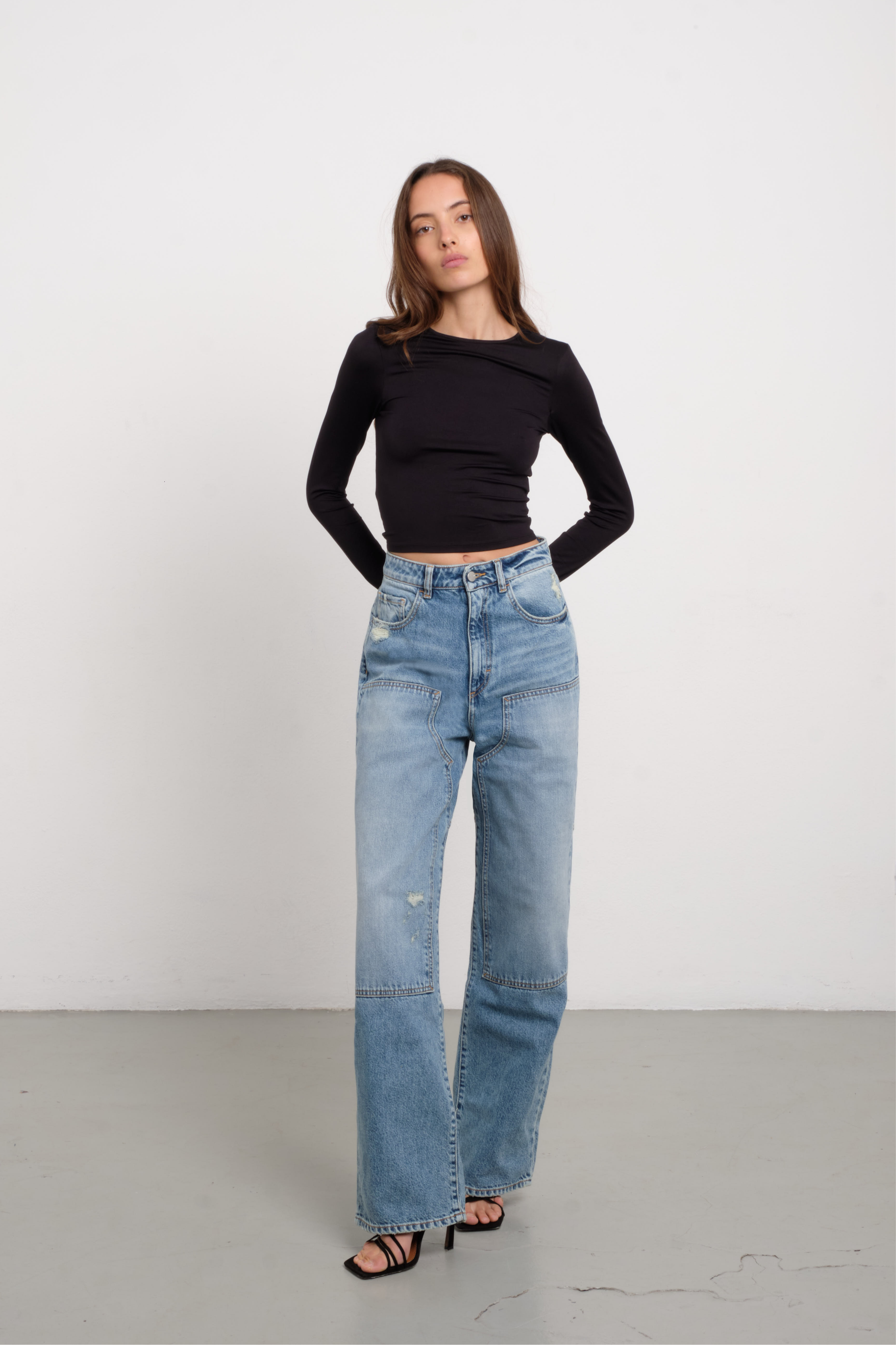 Jenny women’s straight leg jeans in light wash, 100% rigid cotton denim, worn by a model with a black top.