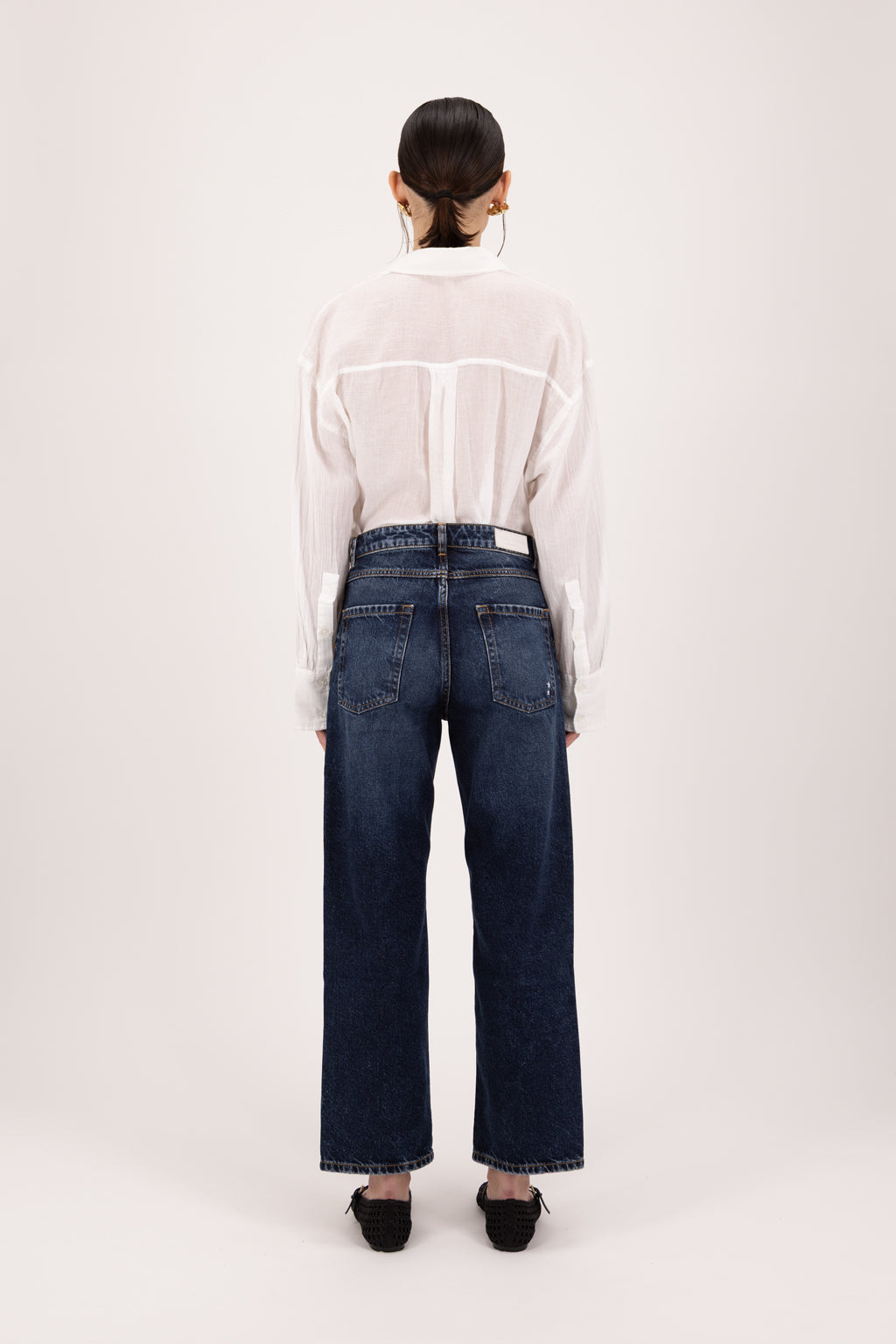 Back view of Jill women’s straight leg jeans in deep blue wash, 100% rigid cotton denim, worn by a model with a white shirt.