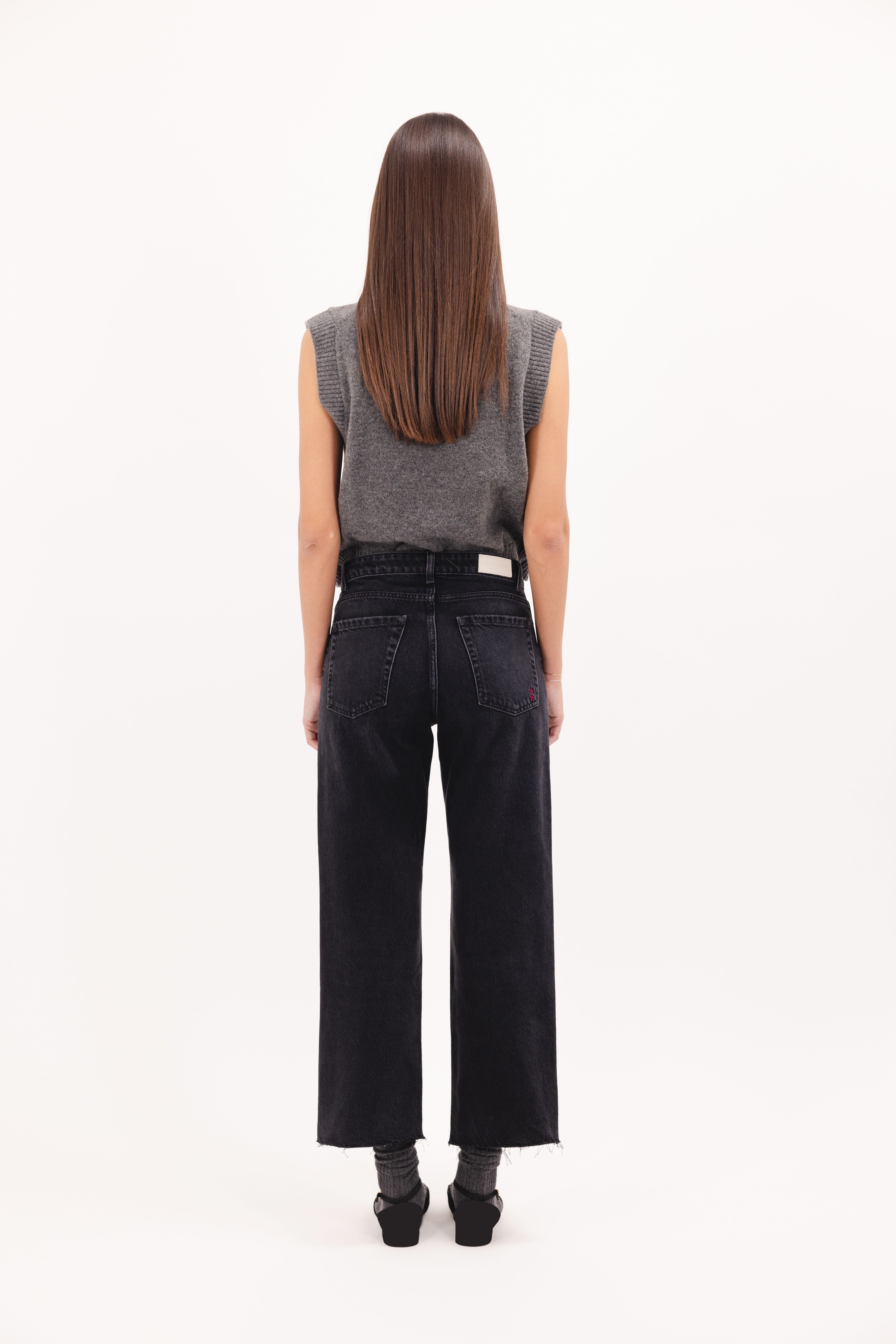 Back view of Jill women’s straight leg jeans in graphite black wash, 100% rigid cotton denim, worn by a model with a gray top.