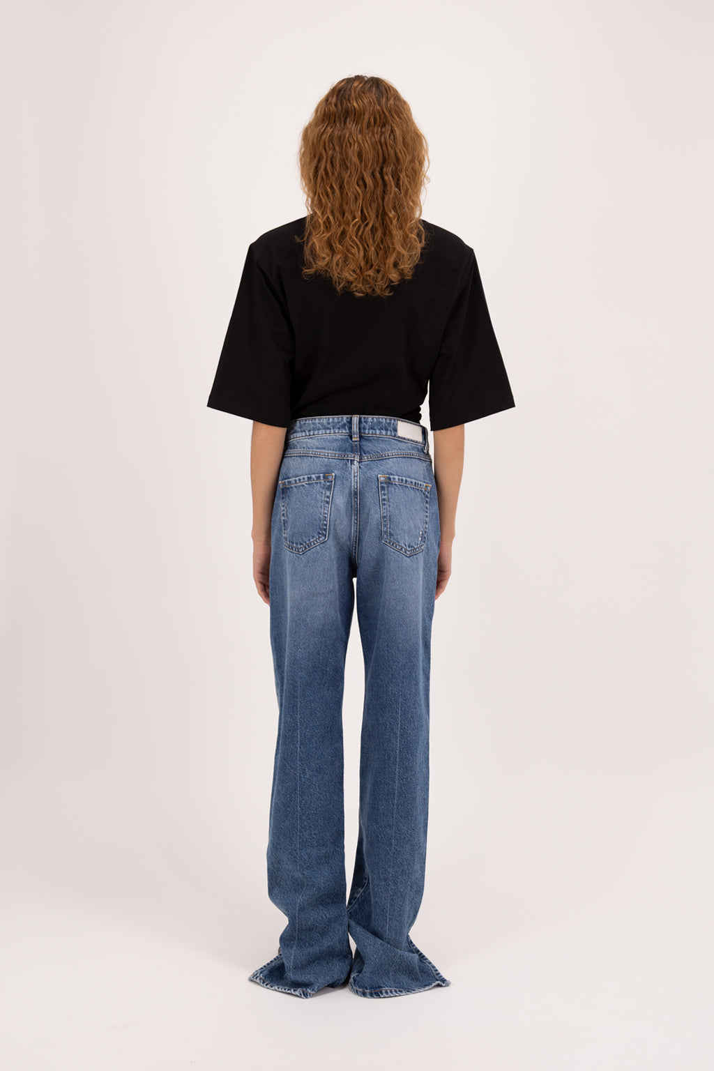 Back view of Jodie women’s straight leg jeans in eclipse wash, 100% rigid cotton denim, worn by a model with a black t-shirt.