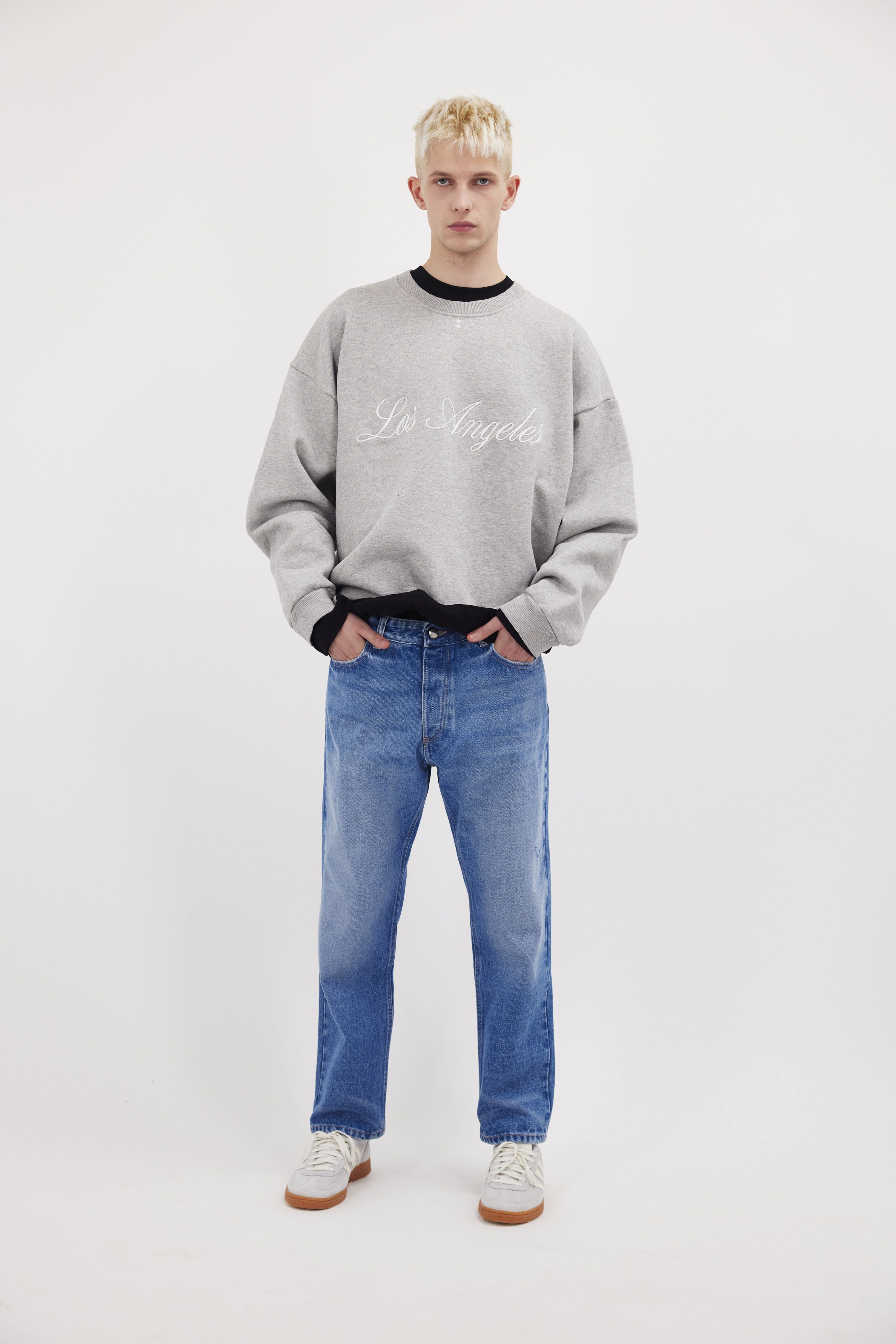 Josh Eco men’s carrot jeans in deep ocean wash, 100% rigid organic cotton denim, worn by a model with a gray sweatshirt.
